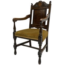 Late 19th to early 20th century oak elbow chair, the shaped cresting rail carved with scrolls and foliage, panelled back inlaid with parquetry work and central rampant lion within shield, upholstered seat, on turned supports joined by H stretchers