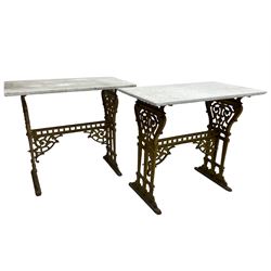 Pair of 19th century cast iron entrance tables, rectangular marble top over ornate gilt bases with scrolling foliate design and sledge feet, united by balustrade stretcher with scroll spandrels