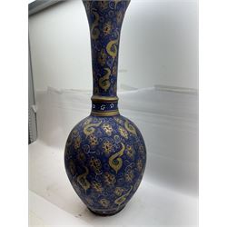 Large and unusual terracotta floor vase, of ovoid form with tall flared neck with frilled rim, decorated with stylised foliate motifs in gilt upon a dark blue ground, H89cm