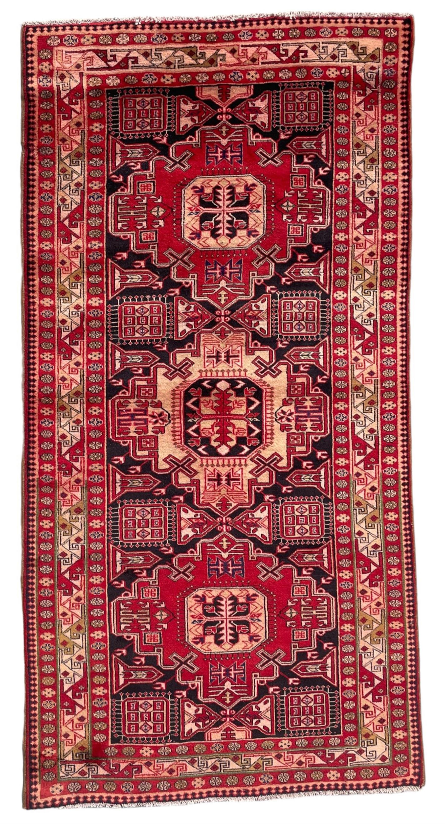 Persian Hamadan indigo and crimson ground rug, the field filled with three shaped medallions, overall geometric design, decorated with sandikli and hac motifs, geometric main border with repeating hooked motifs, within guard stripes decorated with small flower heads, outer crenelated fence band 