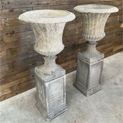 Pair of large Georgian design cast stone garden urns, egg and dart border, tapering column on square base, raised on square column