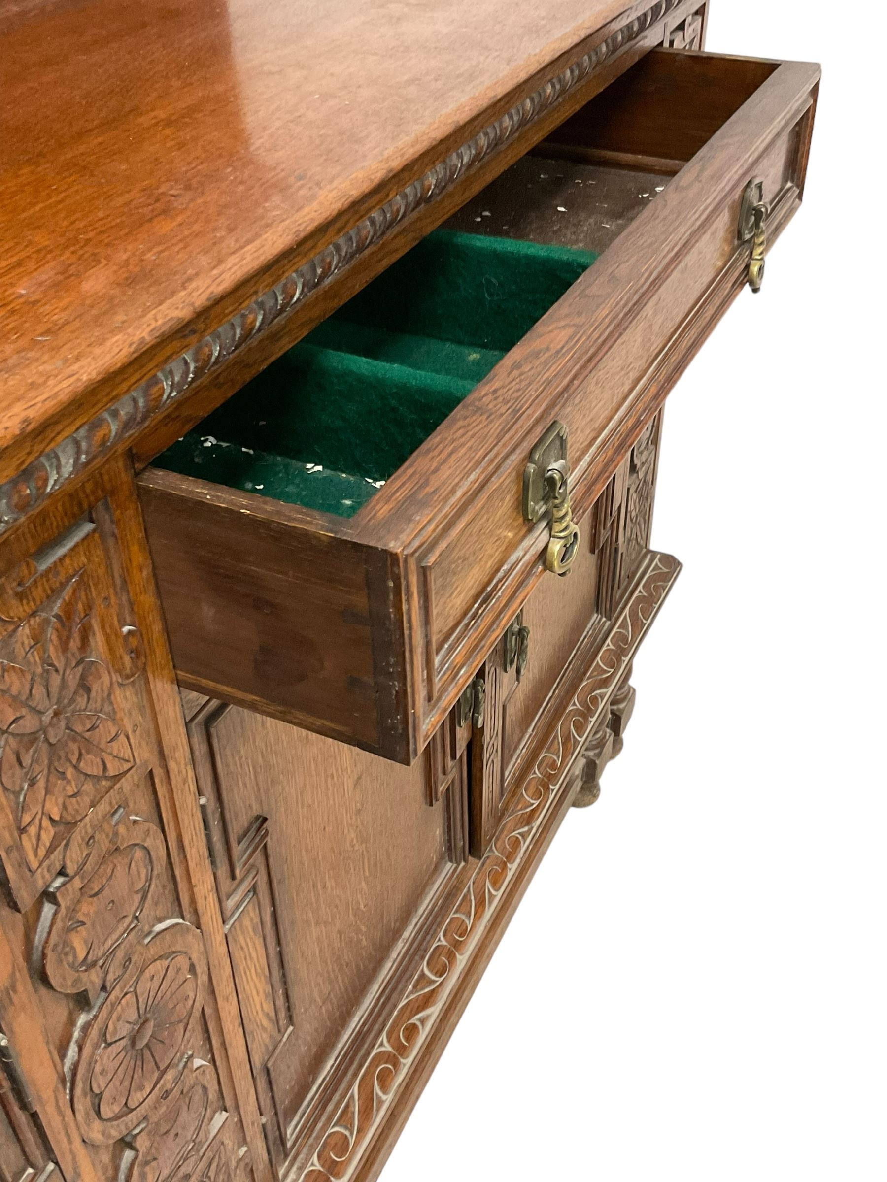 Early 20th century oak sideboard, raised panelled back with foliate carved decoration, rectangular top with gadrooned edge, fitted with two drawers over cupboards with field moulded facias, turned supports joined by stretchers