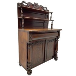 Victorian mahogany chiffonier, raised shaped pediment carved with scrolled extending foliage, two graduating shelves on turned supports, rectangular top over drawer and double cupboard, turned column pilasters, on turned feet 