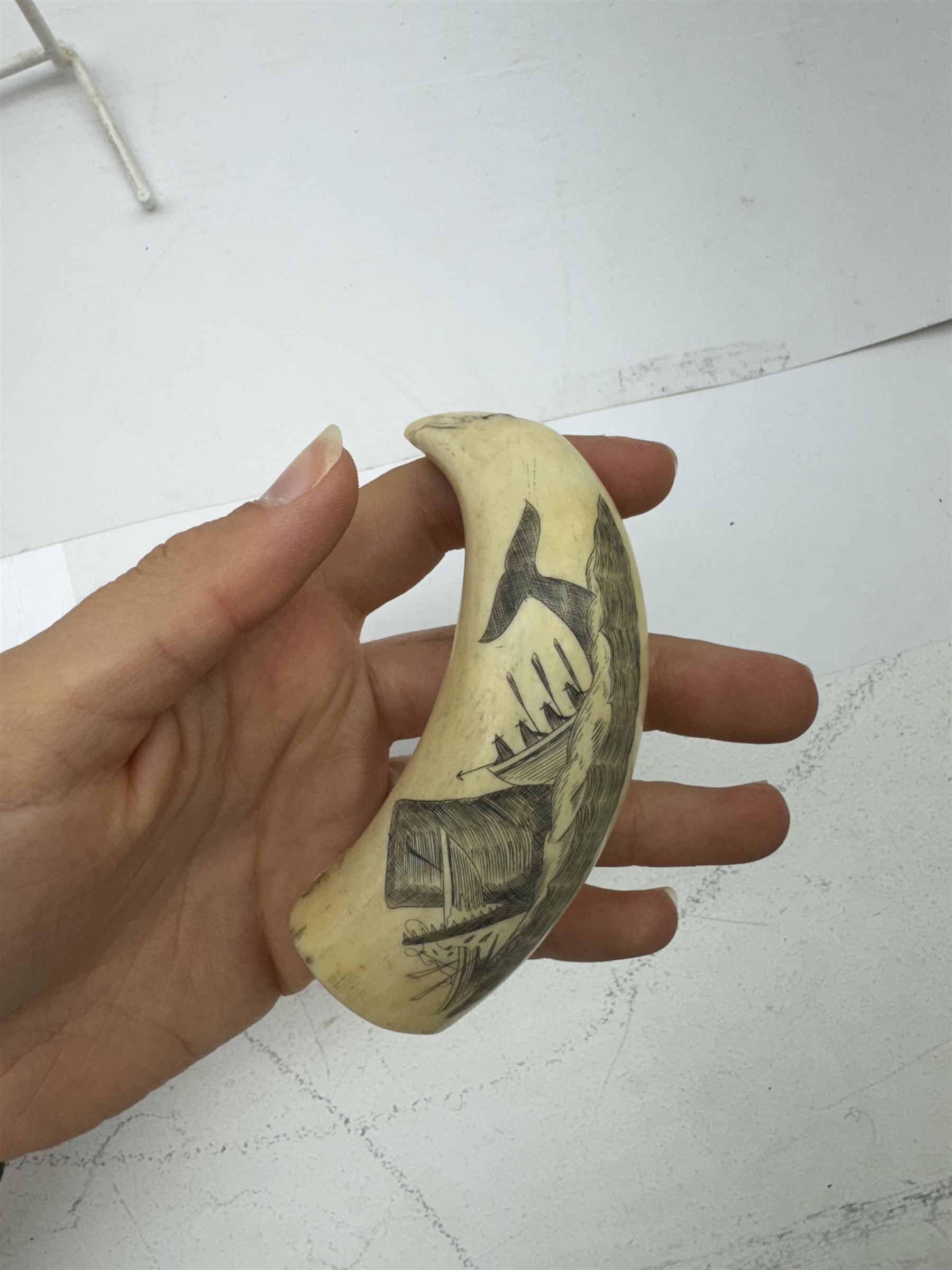 19th century scrimshaw whale tooth, depicting a whale destroying a boat, L9cm