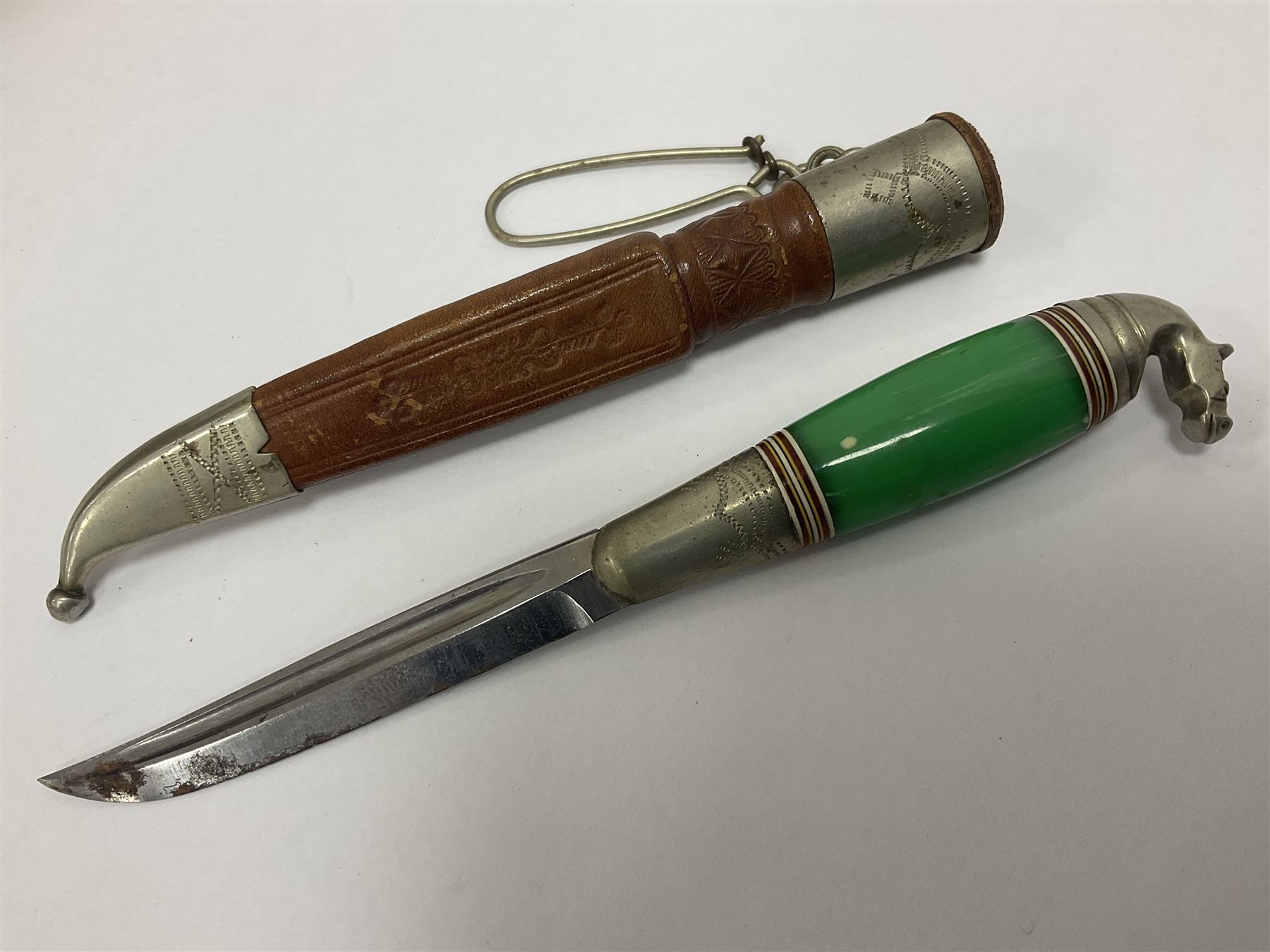 Two Scandinavian bowie knives, the first example with polished green handle with horse head final in white metal, with brown leather sheath, blade L6cm overall L12cm, the second with a polished bone handle, in black sheath with white metal tip, blade L11cm overall 23cm