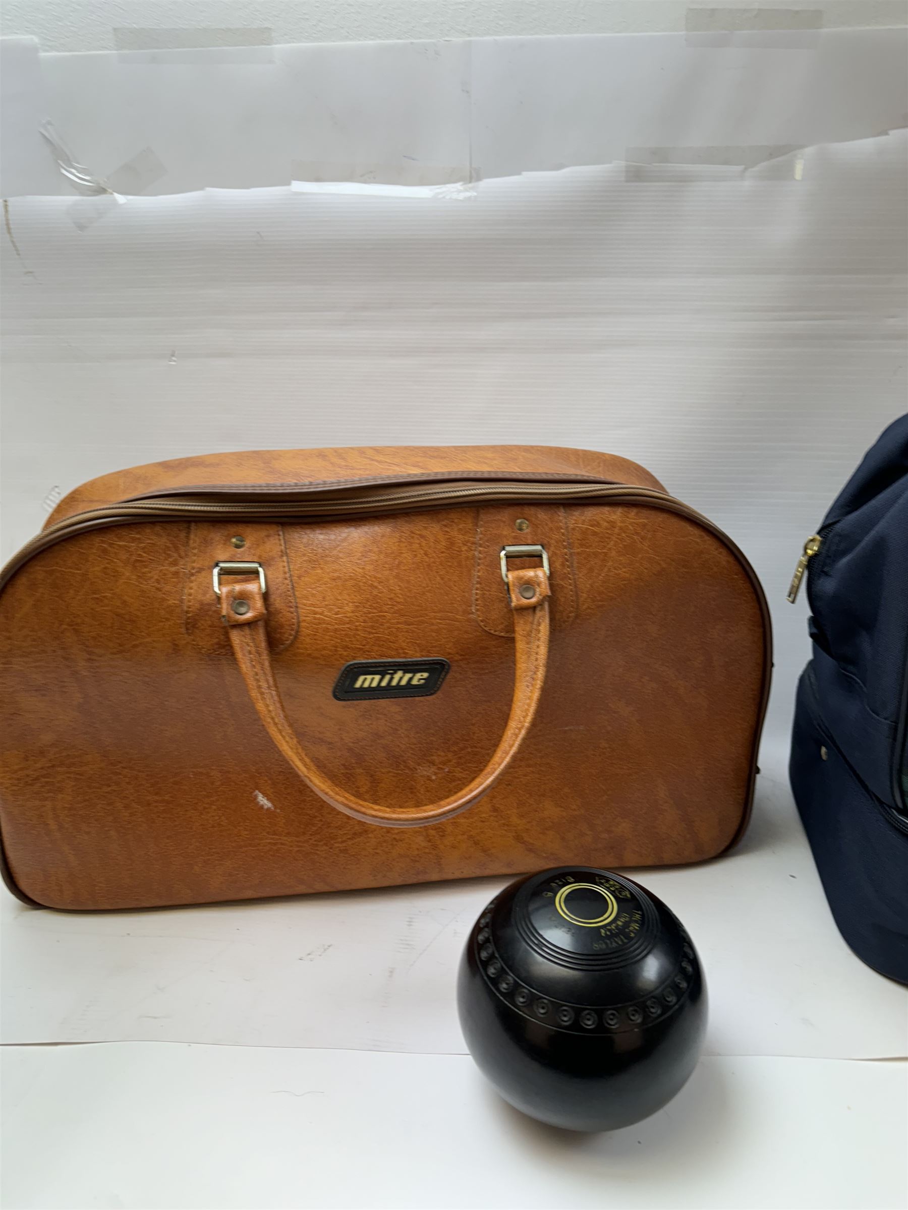 Two sets of flat green bowls, to include a ladies and gentlemans set, both contained within bowling bags