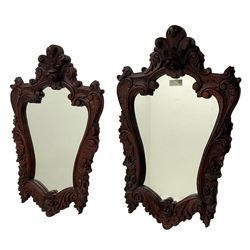 Pair of carved hardwood wall mirrors, shaped floral carved pediment over trailing and scrolled foliage decoration, plain mirror plate 