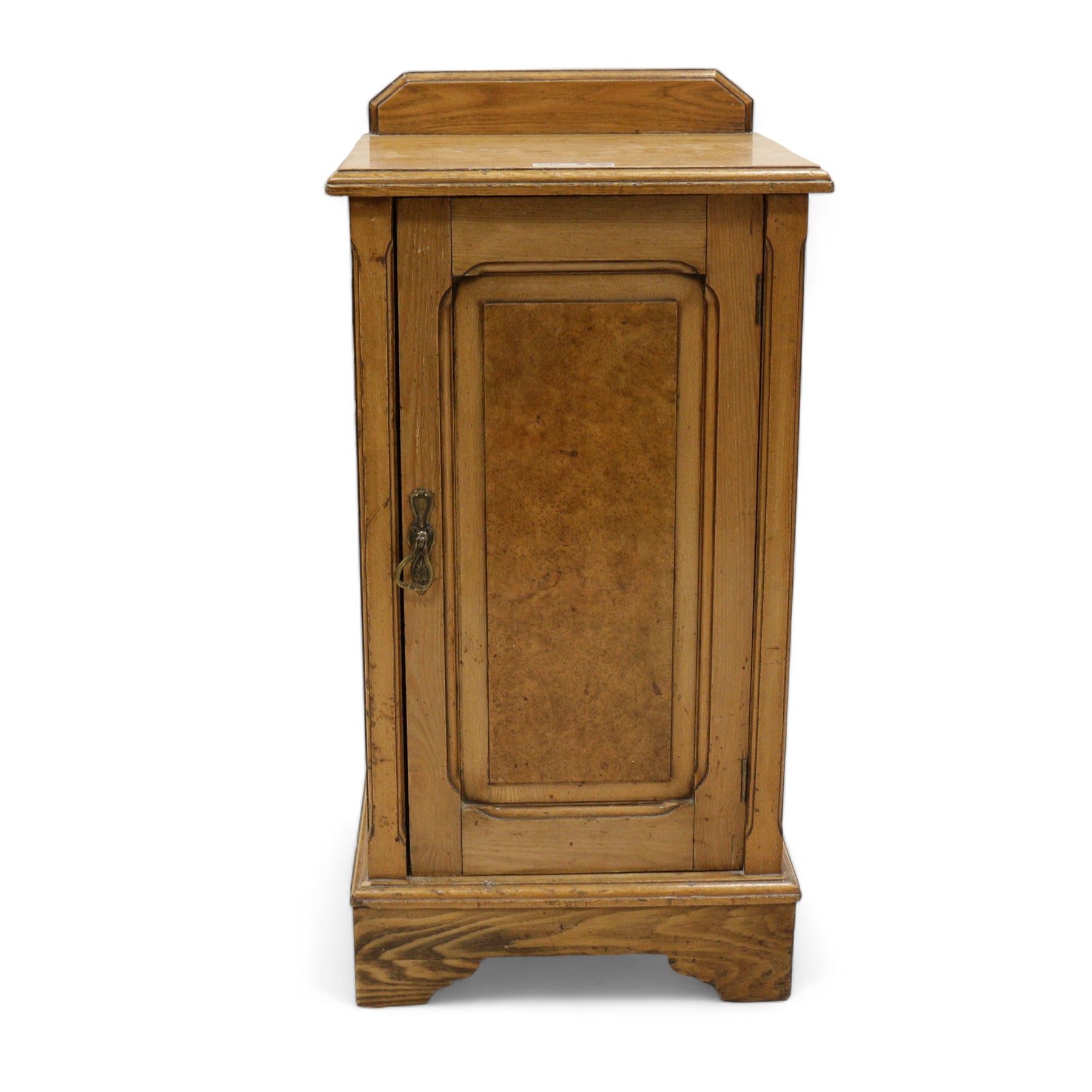 Late Victorian ash and walnut bedside pot cupboard, raised canted back over square moulded top, enclosed by single panelled door with figured walnut veneer, on bracket feet 