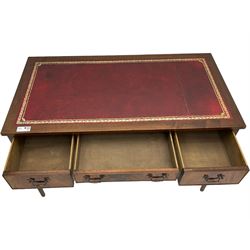 Mid-to-late 20th century mahogany writing desk, the rectangular top with a tooled red leather insert bordered with gilt detailing, three cock-beaded drawers with brass handles, the narrow central drawer flanked by two wider drawers, standing on square tapered legs