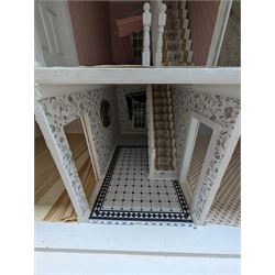 Large three storey modern dolls house, painted white with latticed windows, grey roof and metal fencing, with decorated interior, together with two dolls house garden rooms and two conservatories