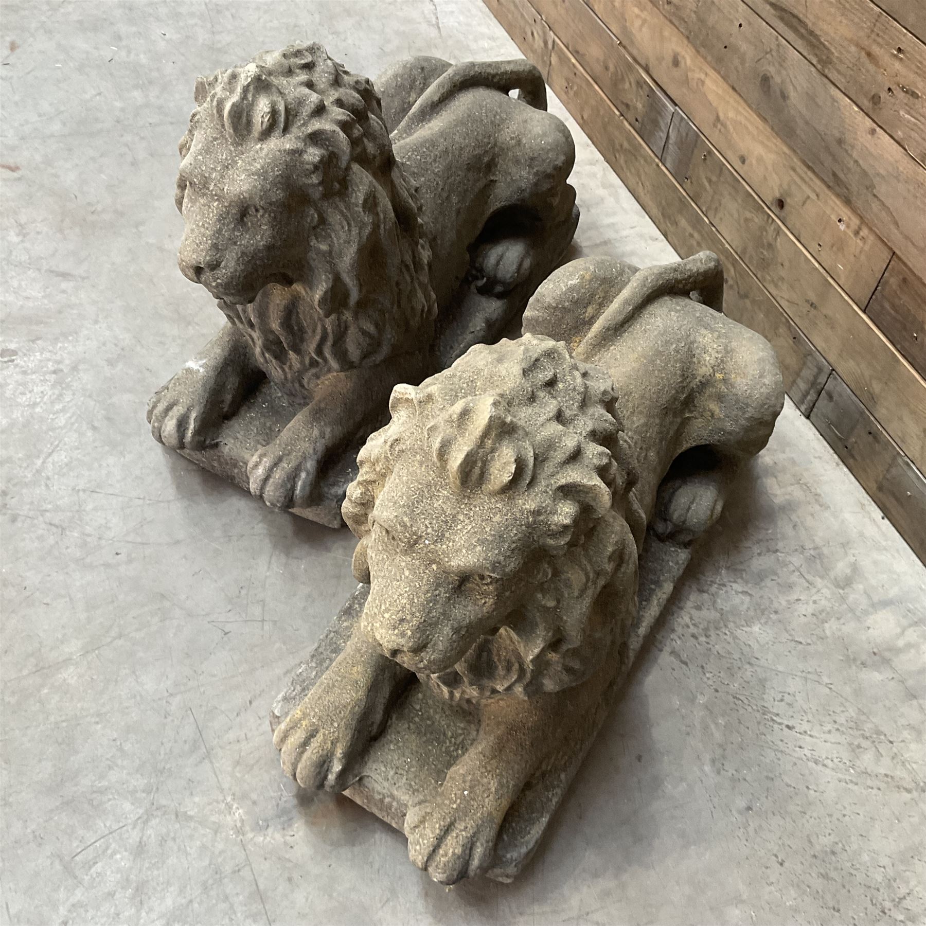 Pair of large cast stone Langport recumbent garden lions, rectangular plinth base