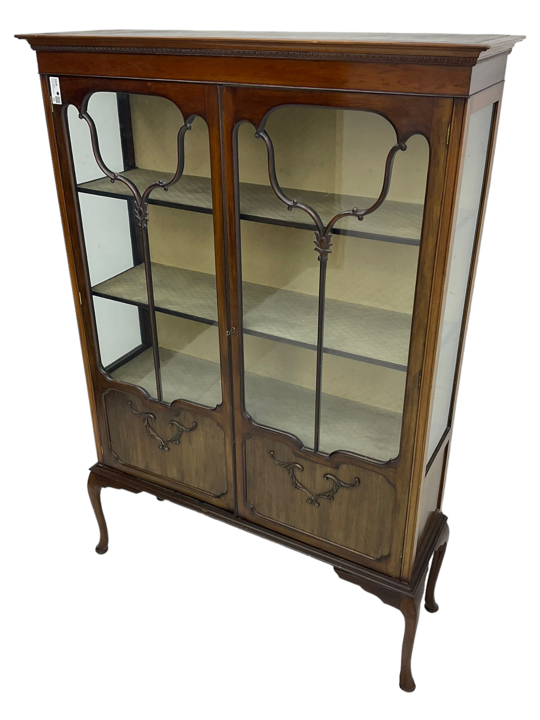 Early 20th century mahogany straight-front display cabinet, projecting moulded cornice over two astragal glazed doors with lower panels, on cabriole supports 