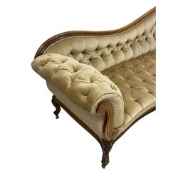 19th century walnut framed chaise longue, shaped back over scrolled arms decorated with moulded curling acanthus carvings, upholstered in deep buttoned champagne fabric, raised on cabriole supports with applied floral carved decoration, on castors