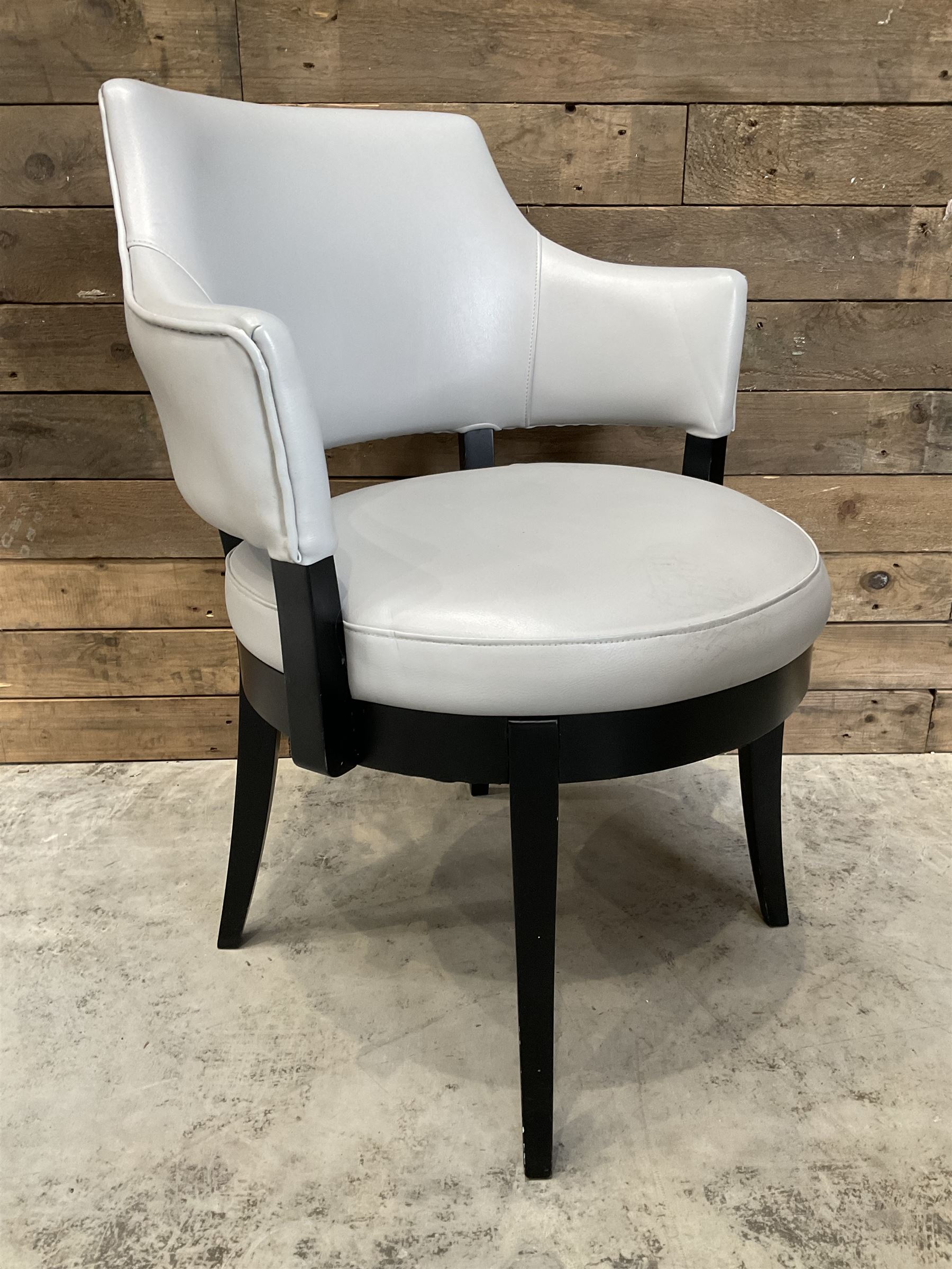 Four ebonised framed tub shaped armchairs, upholstered in grey fabric