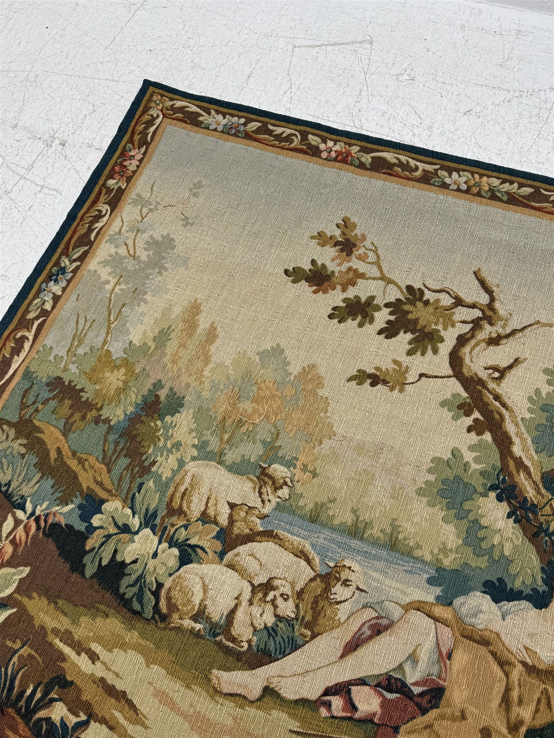 Large French machine woven tapestry, depicting figures in a landscape with a floral boarder 