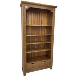 John Lewis - 'Bergerac' oak bookcase, projecting moulded cornice over four adjustable open shelves, two drawers to the base with cut-out handles, on square tapered supports