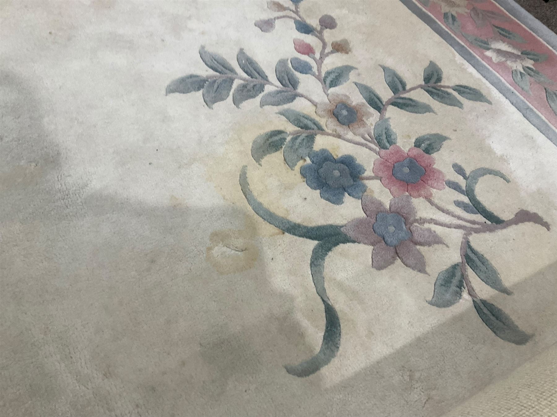 Chinese ivory ground washed woollen carpet, the field decorated with five large floral motifs with extending leafage, the wide rose guard band decorated with further floral patterns