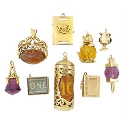 Nine gold pendant / charms including money roll, stone set cat, swivel fob, lanterns, passport etc, all 9ct