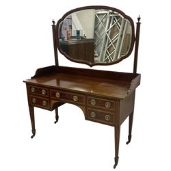 Edwardian inlaid mahogany kneehole dressing table, raised shaped oval bevelled mirror back, fitted with five drawers with banding and stringing, on square tapering supports with castors