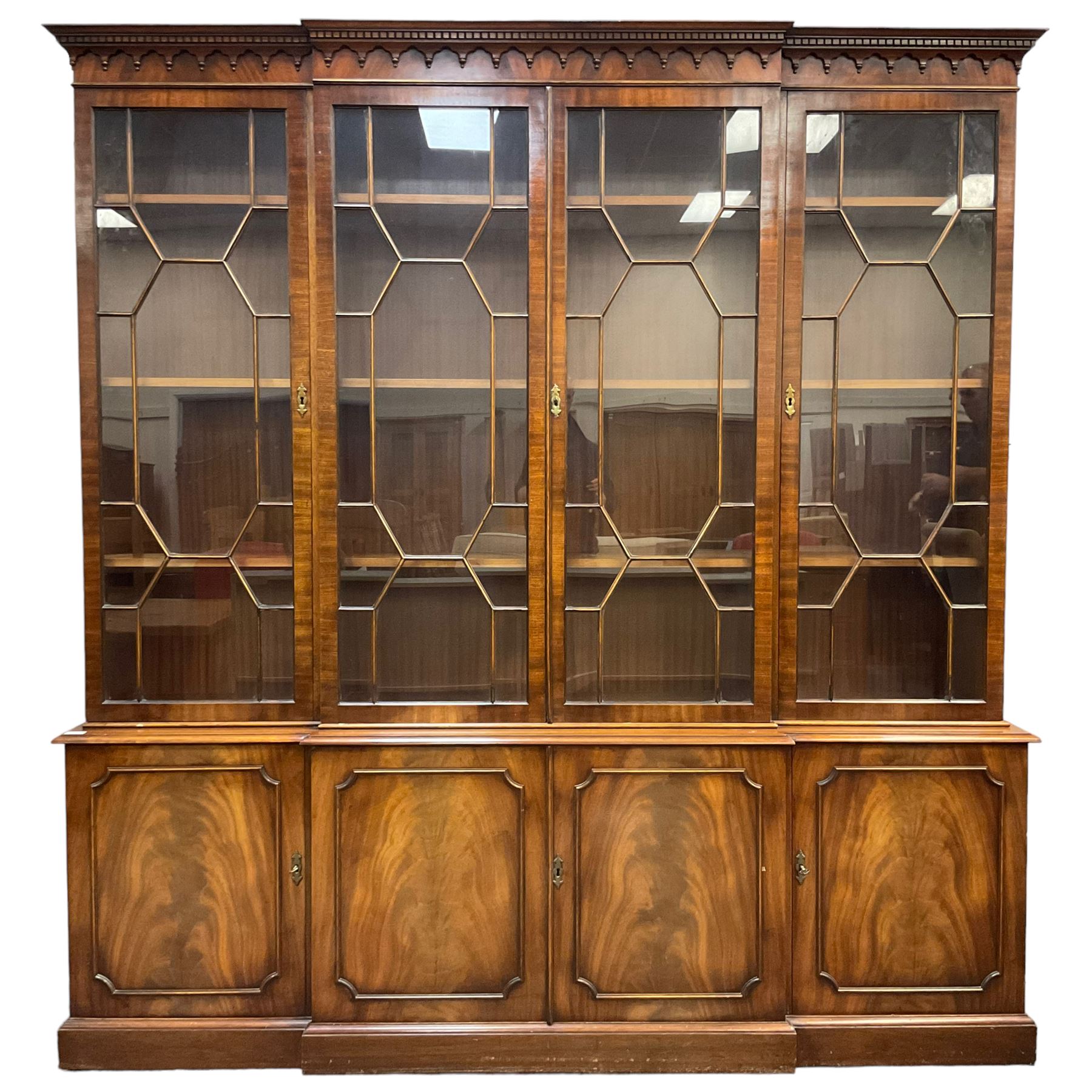 Bevan Funnell - Georgian design mahogany breakfront bookcase, moulded dentil and arcaded frieze over four astragal glazed doors, four cupboards below enclosed by figured doors, on skirted base