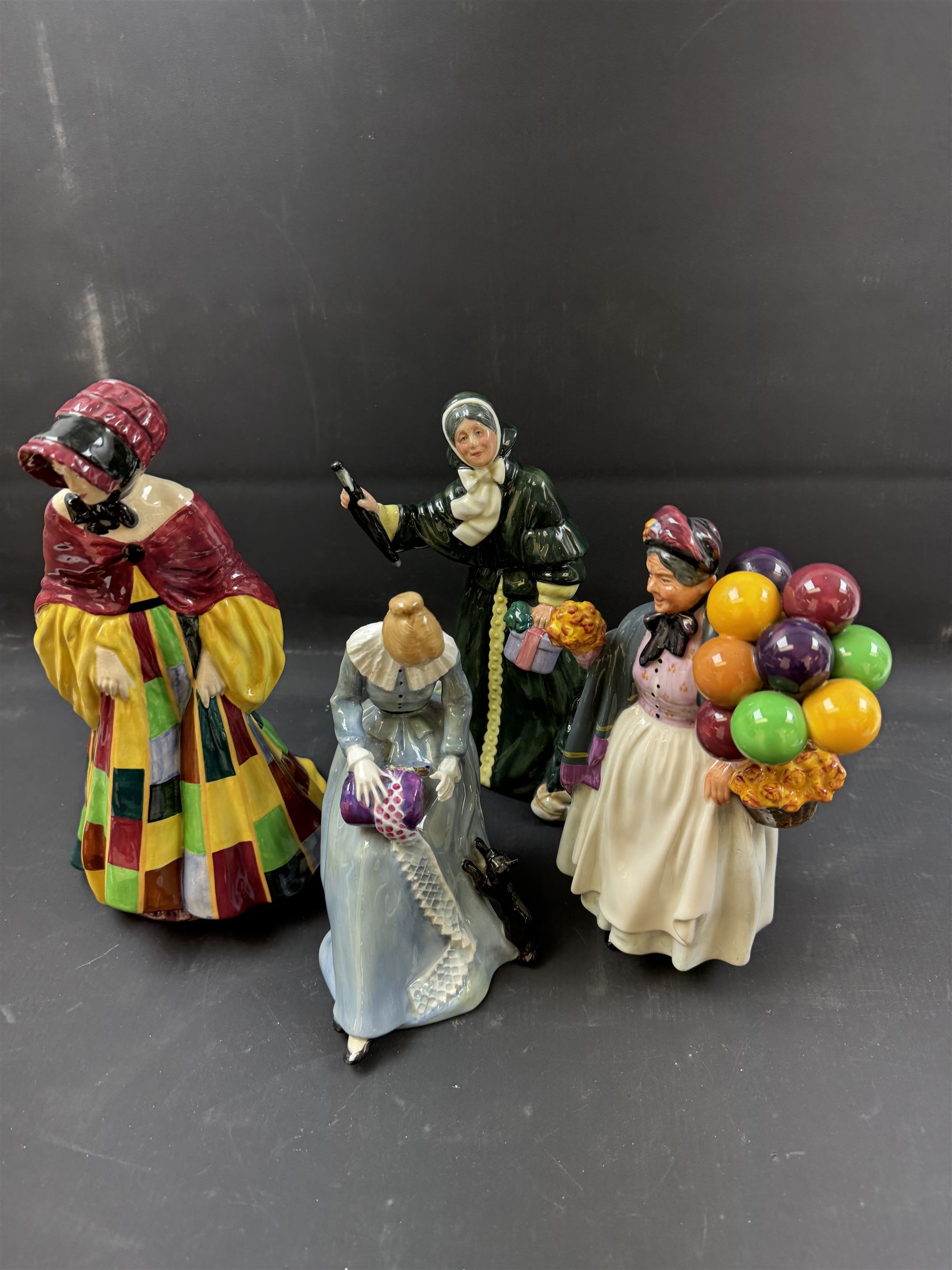 Four Royal Doulton figures, comprising The Parson's Daughter HN564, Dorothy HN3098, Christmas Parcels HN2851 and Biddy Pennyfarthing HN1843