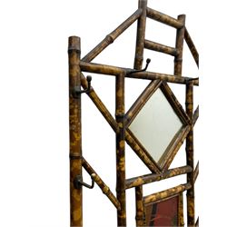 Victorian bamboo hallstand, bevelled mirror over red lacquered and chinoiserie decorated panels, fitted with six brass hooks 