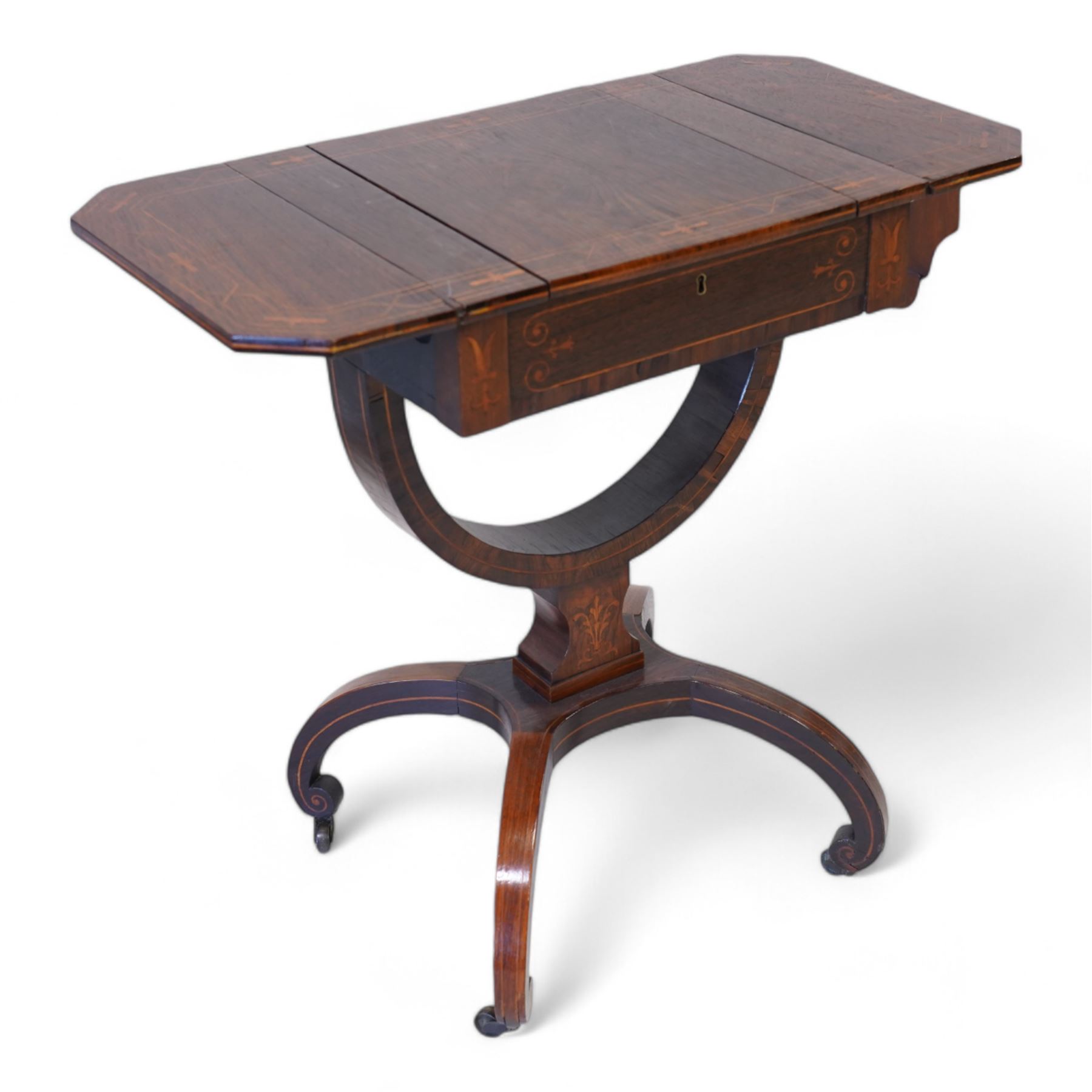 Victorian inlaid rosewood work or sewing table, the rectangular drop-leaf top with canted corners and inlaid with geometric banding, the hinged lid opening to reveal a central compartment surrounded by divisions, raised on a U-support terminating to arched supports with castors