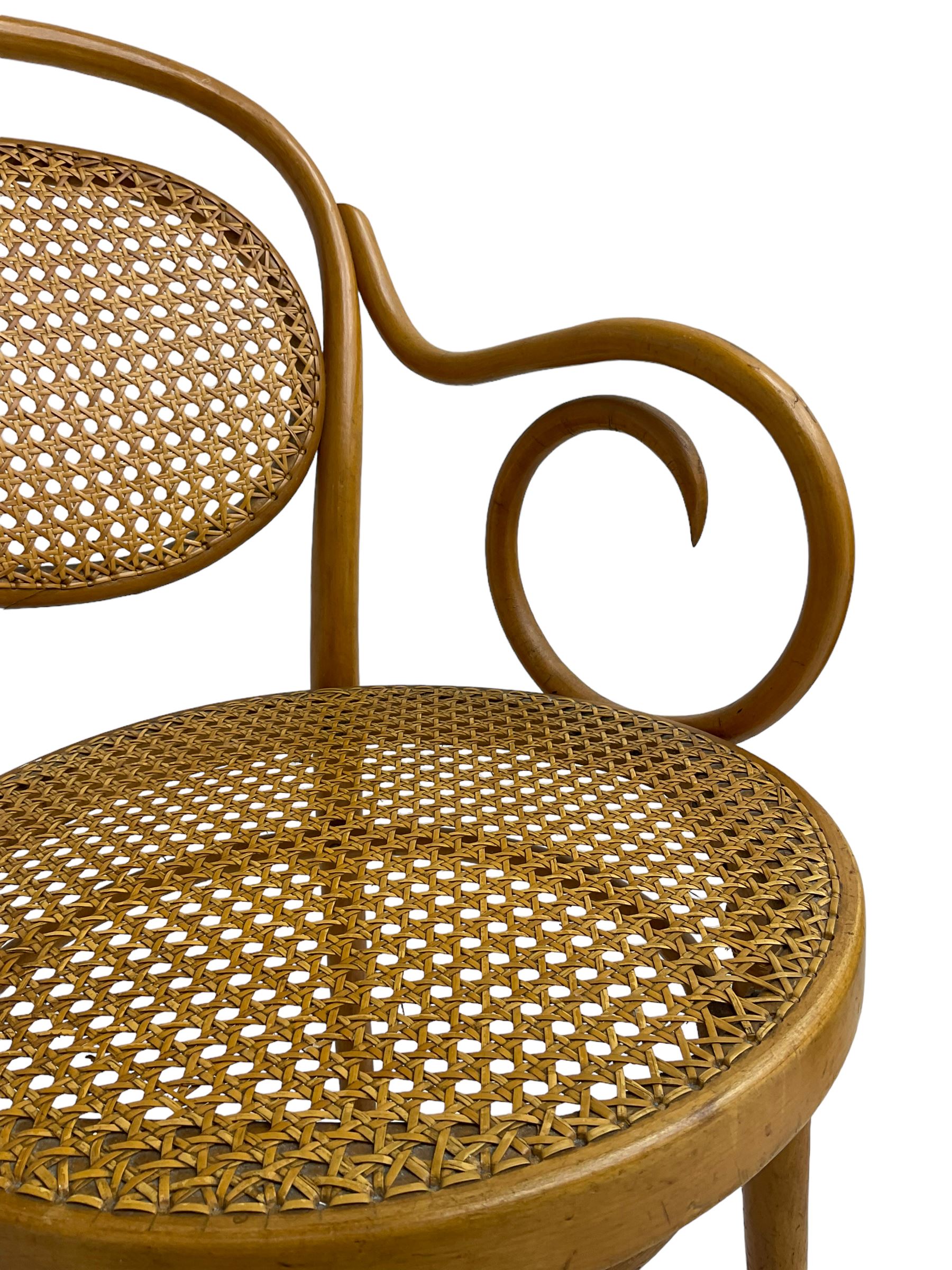 After Michael Thonet - bentwood armchair, circular cane seat and back, scrolled arms