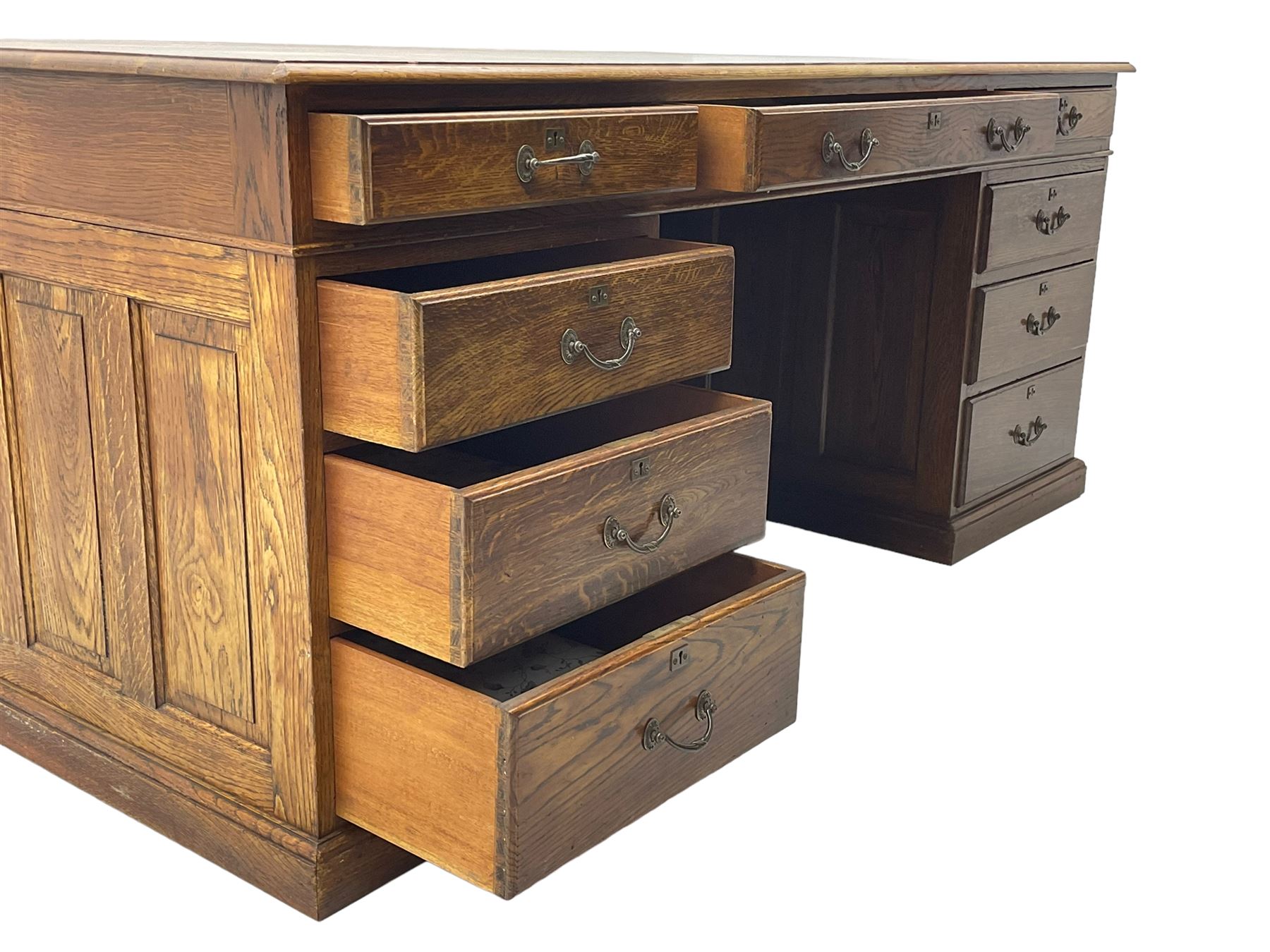 Large 20th century oak twin pedestal desk, moulded rectangular top over nine drawers, panelled pedestals, on moulded plinth base 