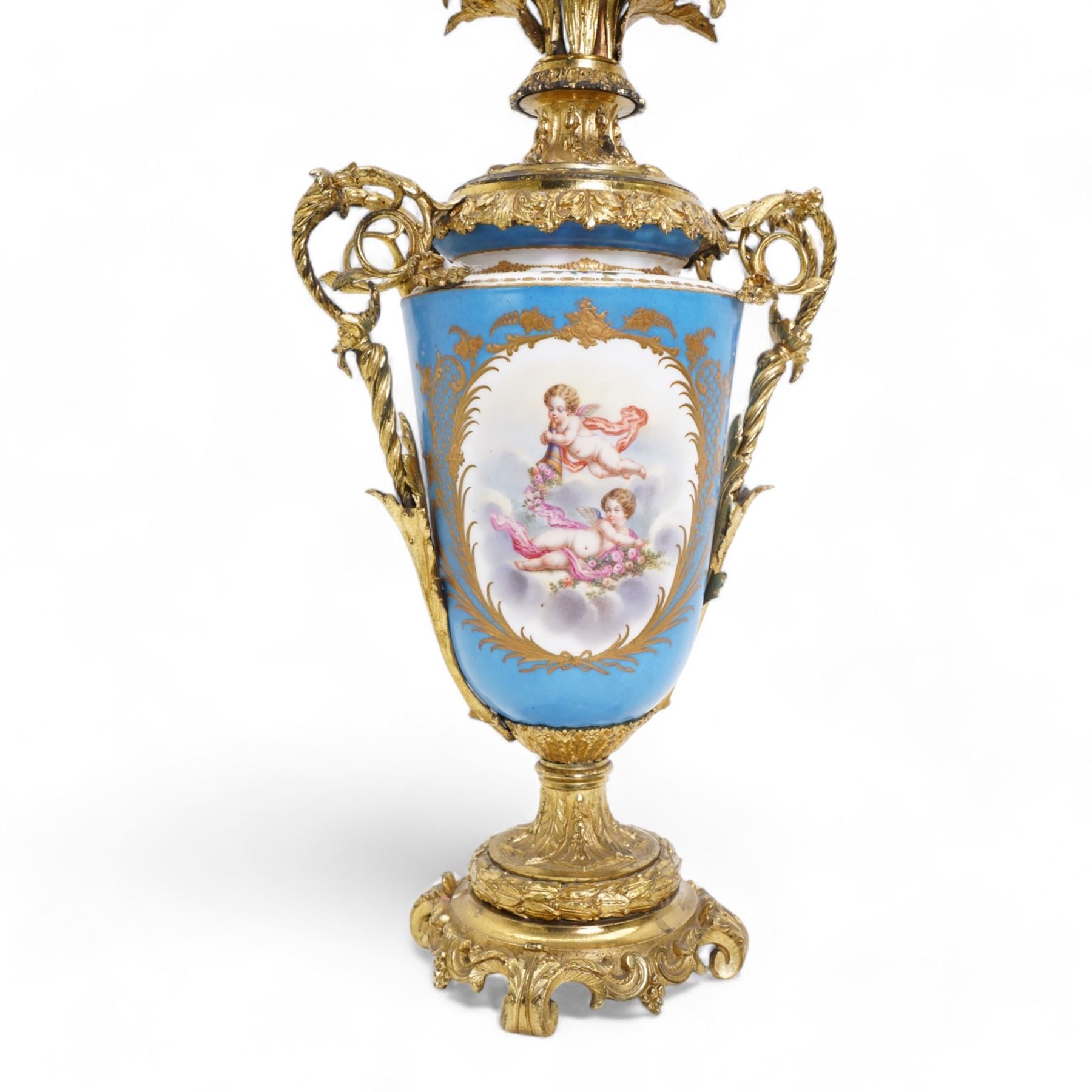 Pair of 19th century Sevres pattern porcelain and ormolu six light candelabra, each with branches cast as lilies, carnations etc, the two handled vase shaped base with oval panels painted with cherubs amongst flowers on a bleu de ciel surround and raised on an ormolu foliate stem and circular base with scrolling bracket feet H76cm (2)  