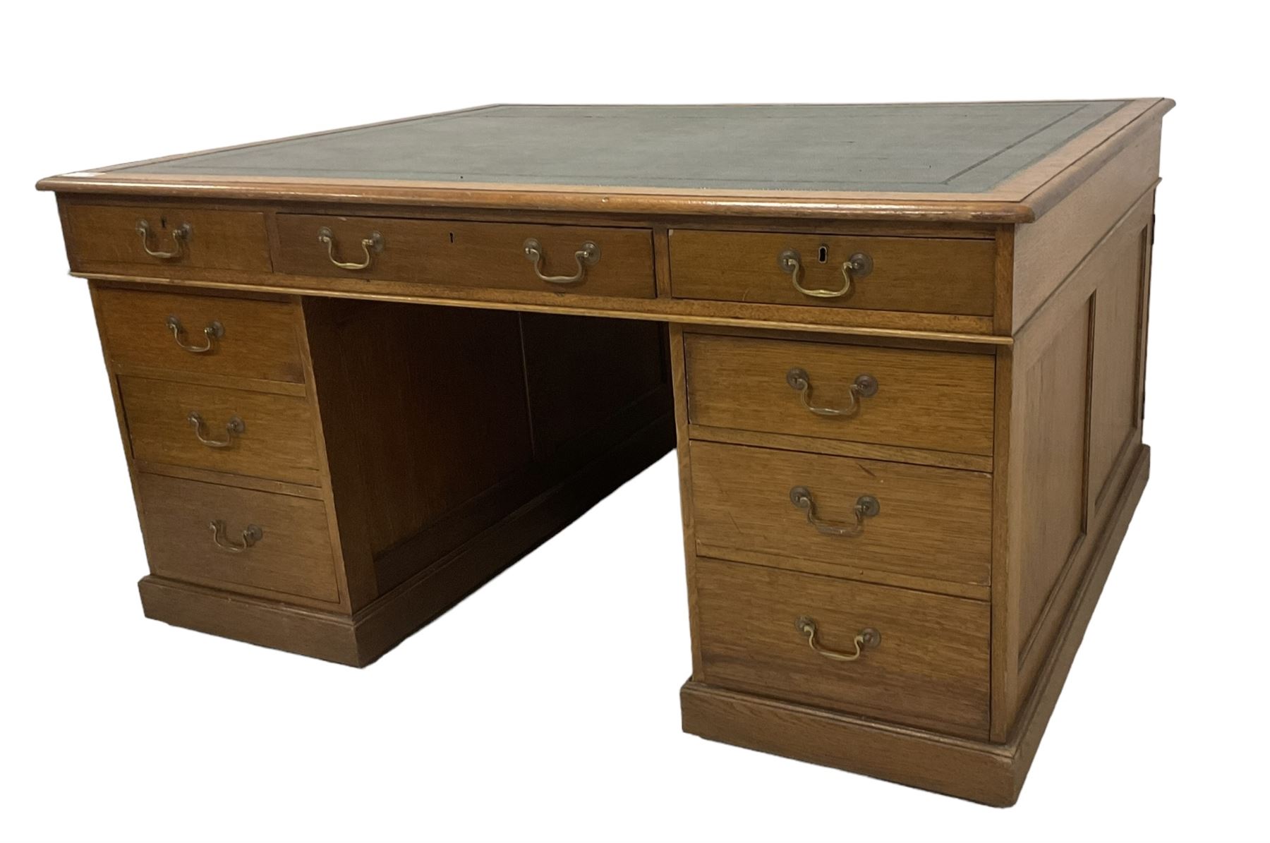 Late 19th century twin pedestal oak partner's desk, rectangular top with inset green leather writing surface, fitted with nine graduating drawers to each side, the rear drawers enclosed by panelled cupboards