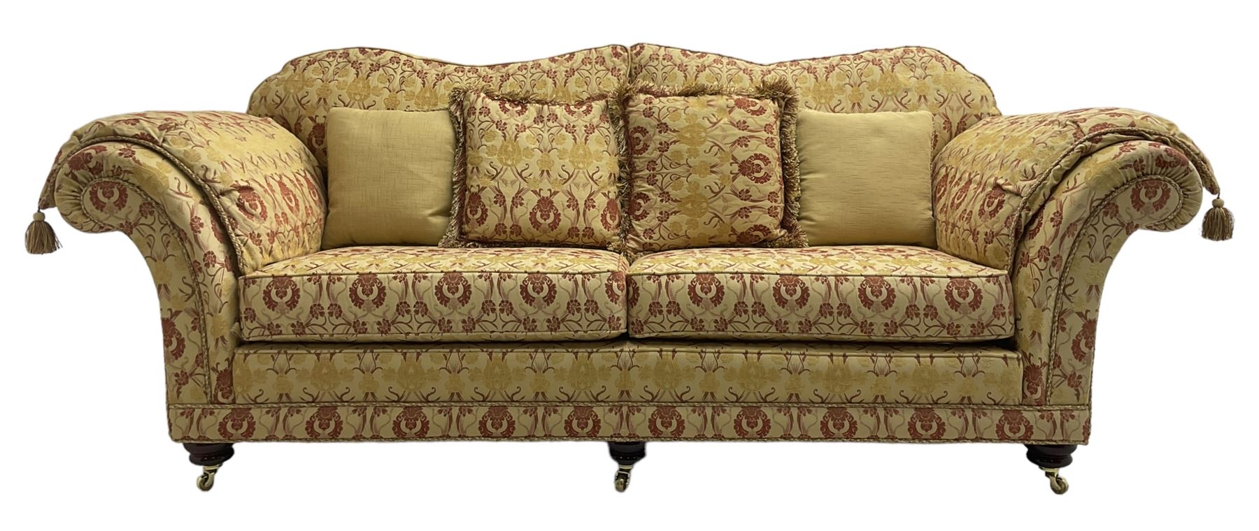 Steed Upholstery Ltd. - 'Lincoln' three-seat sofa upholstered in gold 'Olympia' floral pattern corded and tasselled fabric, together with scatter cushions and arm covers, on turned feet with brass castors