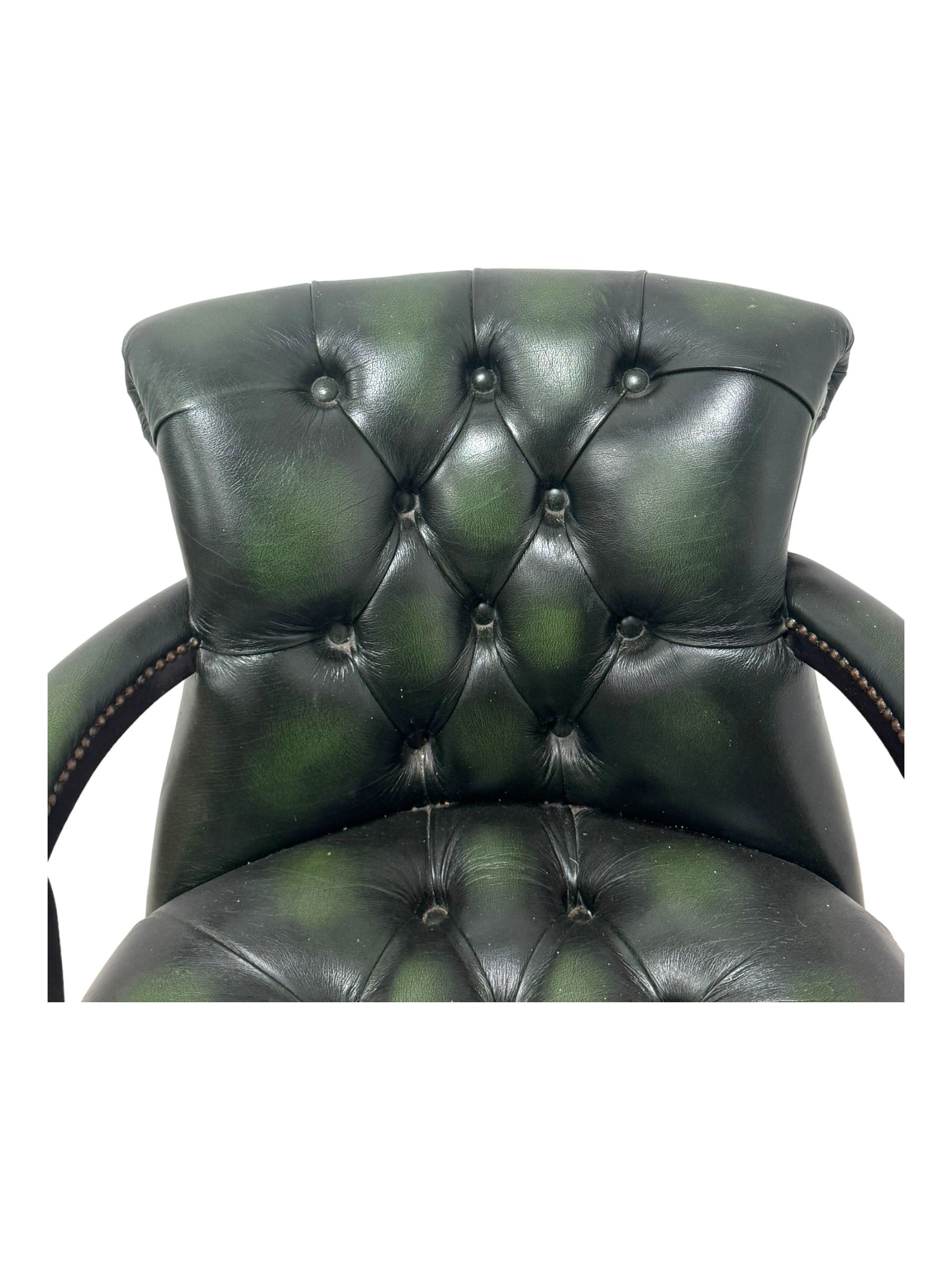 Victorian design Captains swivel desk chair, rolled tub shaped back with open arms, upholstered in deep buttoned green leather with studwork border