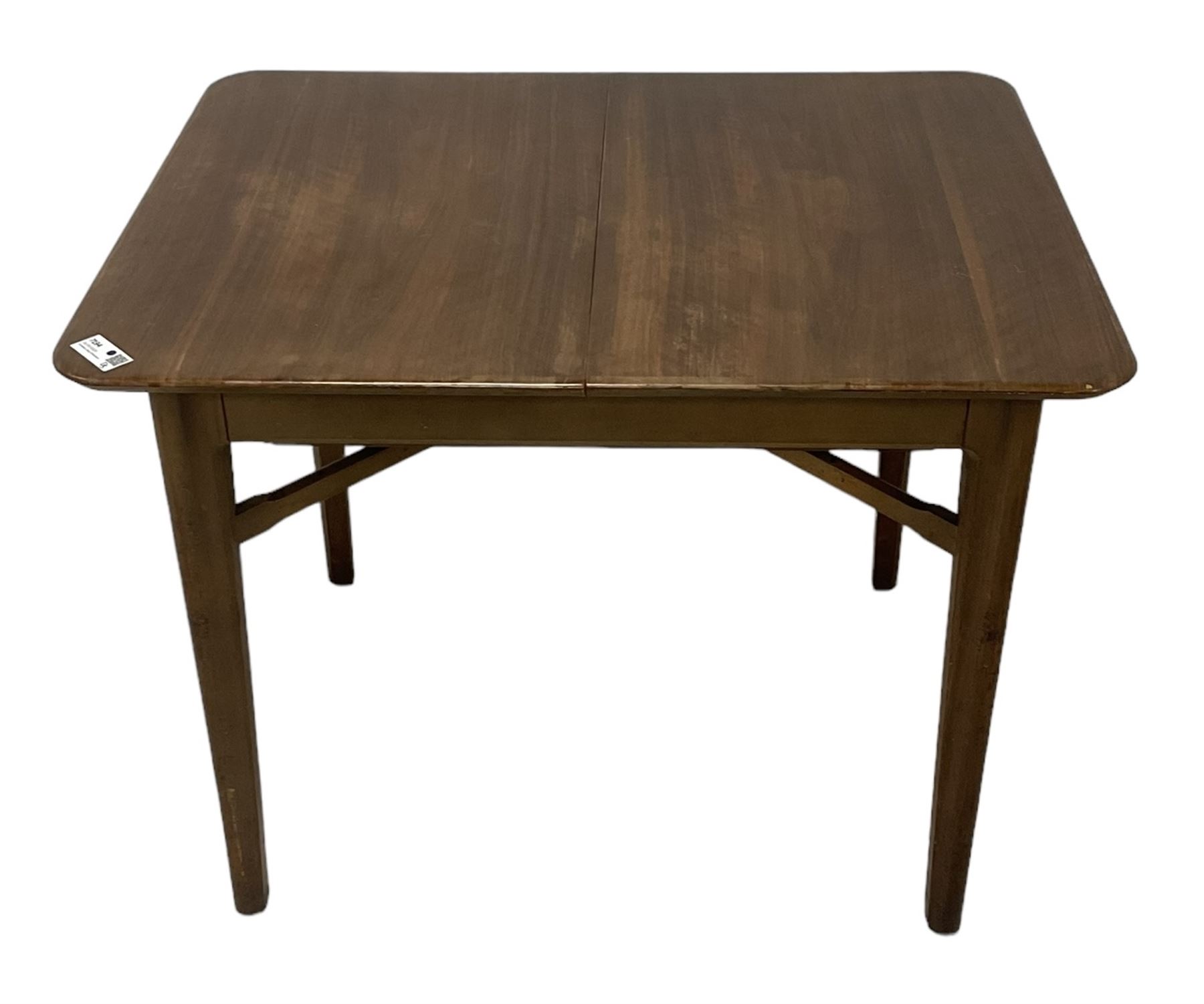 Mid-20th century teak extending dining table, rectangular top with rounded corners, raised on shaped tapering supports united by X-stretcher, with additional leaf