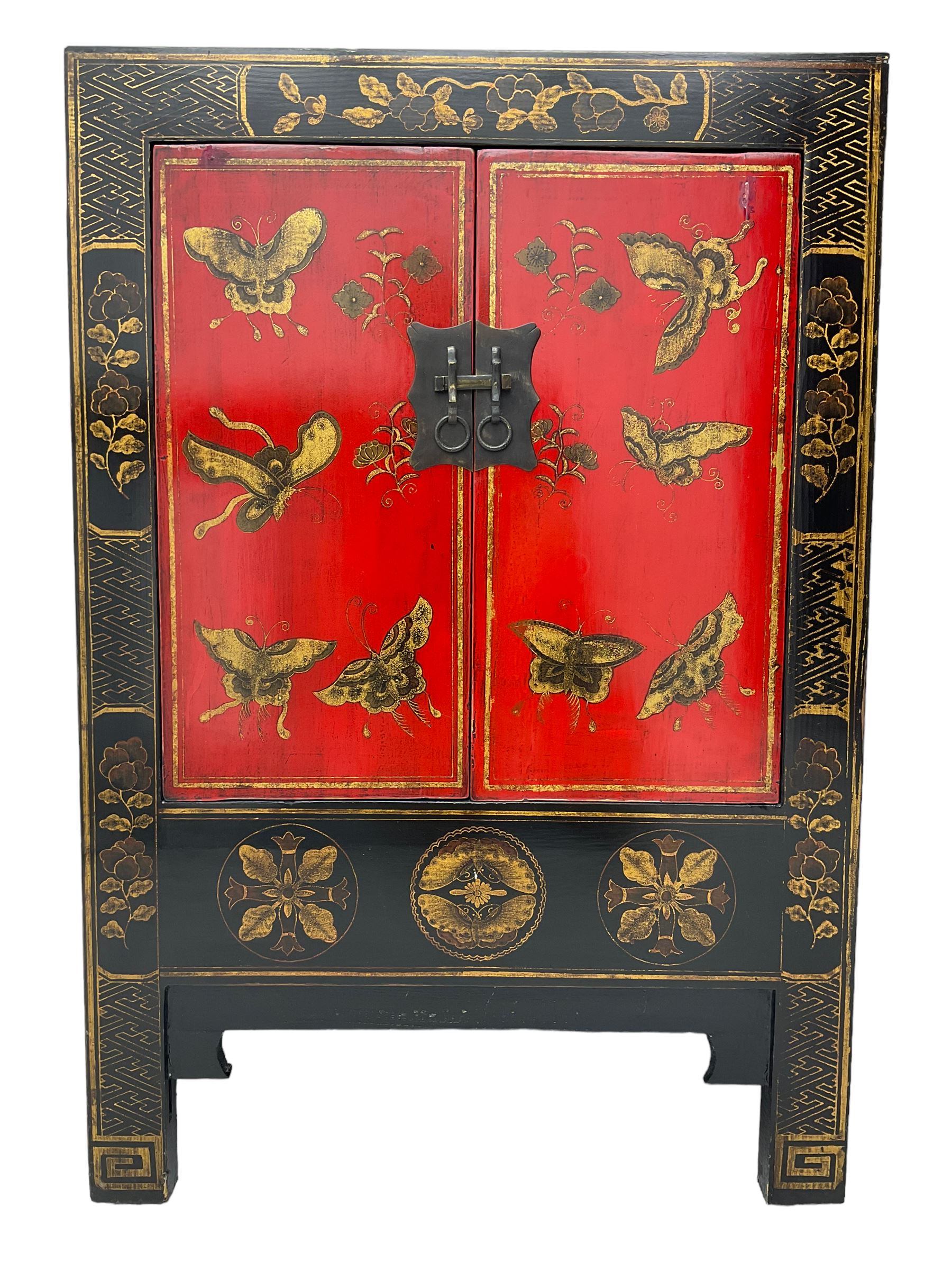 20th century Chinese black lacquered cabinet, rectangular body with two doors enclosing single shelf interior, adorned with gilt butterfly and floral motifs against a red backdrop, standing on square supports