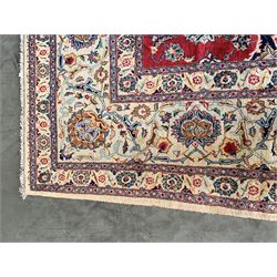 Large Fine Persian Kashan rug, red ground field decorated with large stylised flower heads, the ivory ground border with matching motifs and trailing foliage