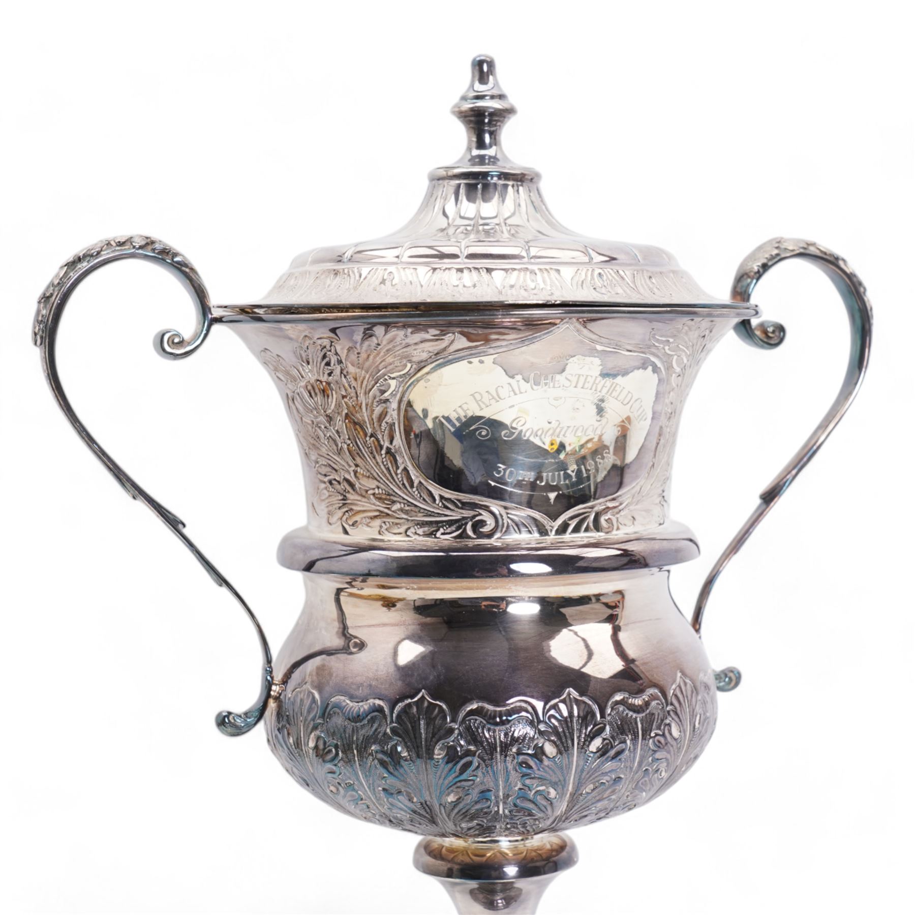 'The Racal Chesterfield Cup, Goodwood 30th July 1988' - Edwardian silver two handled cup and cover with scroll handles and leaf decoration on wooden base H52cm overall Birmingham 1908 Maker Jones & Crompton