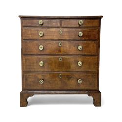 George I walnut chest, moulded rectangular top with book-matched veneers within crossbanding, fitted with two short over four long graduating drawers, moulded drawer fronts with brass handles, on bracket feet, the chest will split into two sections 