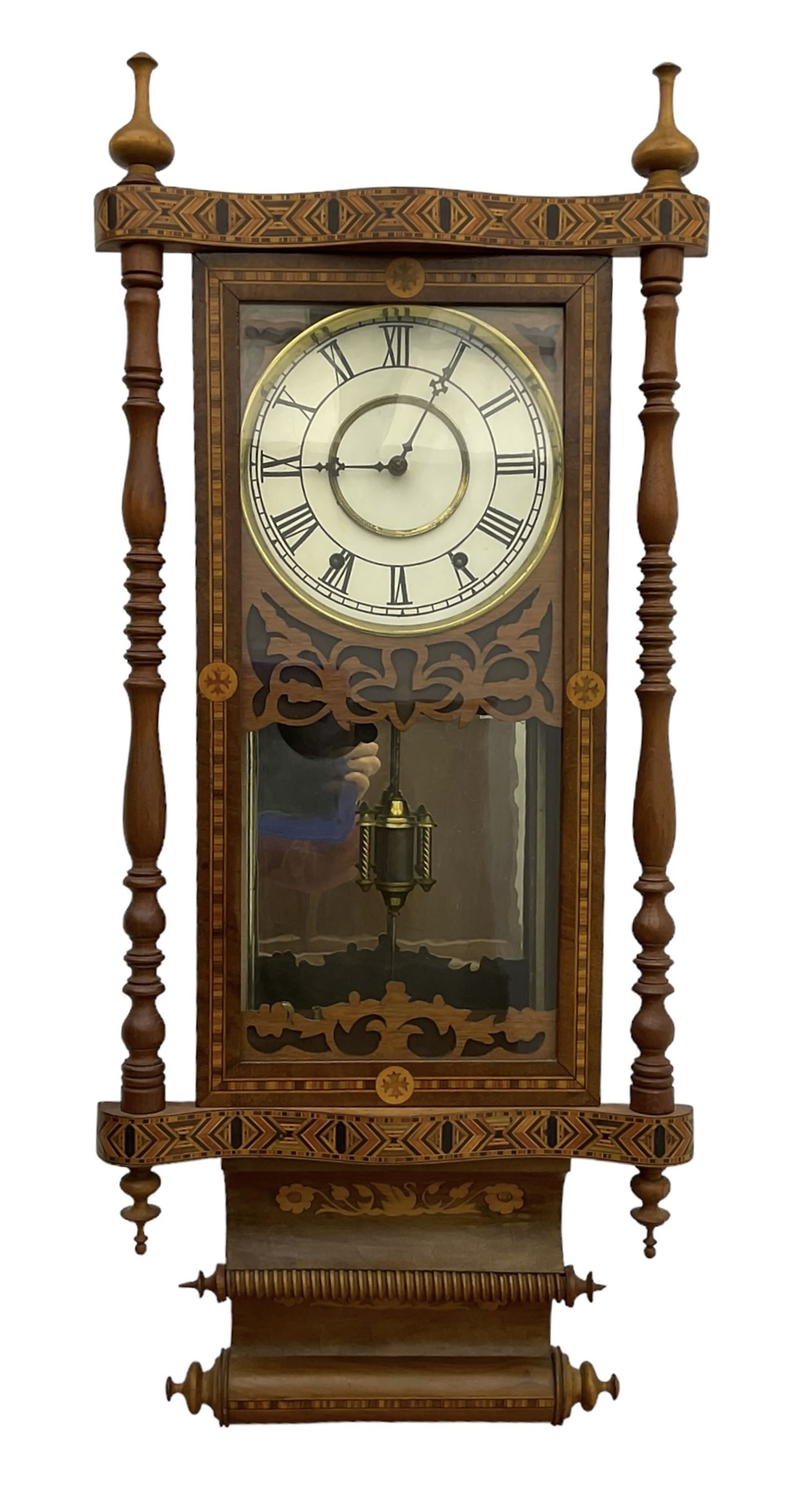 New Haven - American 19th century 8-day wall clock, inlaid parquetry case with fretwork, ring turned pilasters and finials, dial with Roman numerals, minute track and steel hands, with a visible faux mercury pendulum and mirror to the rear of the case, count wheel two train spring driven movement striking the hours on a bell.