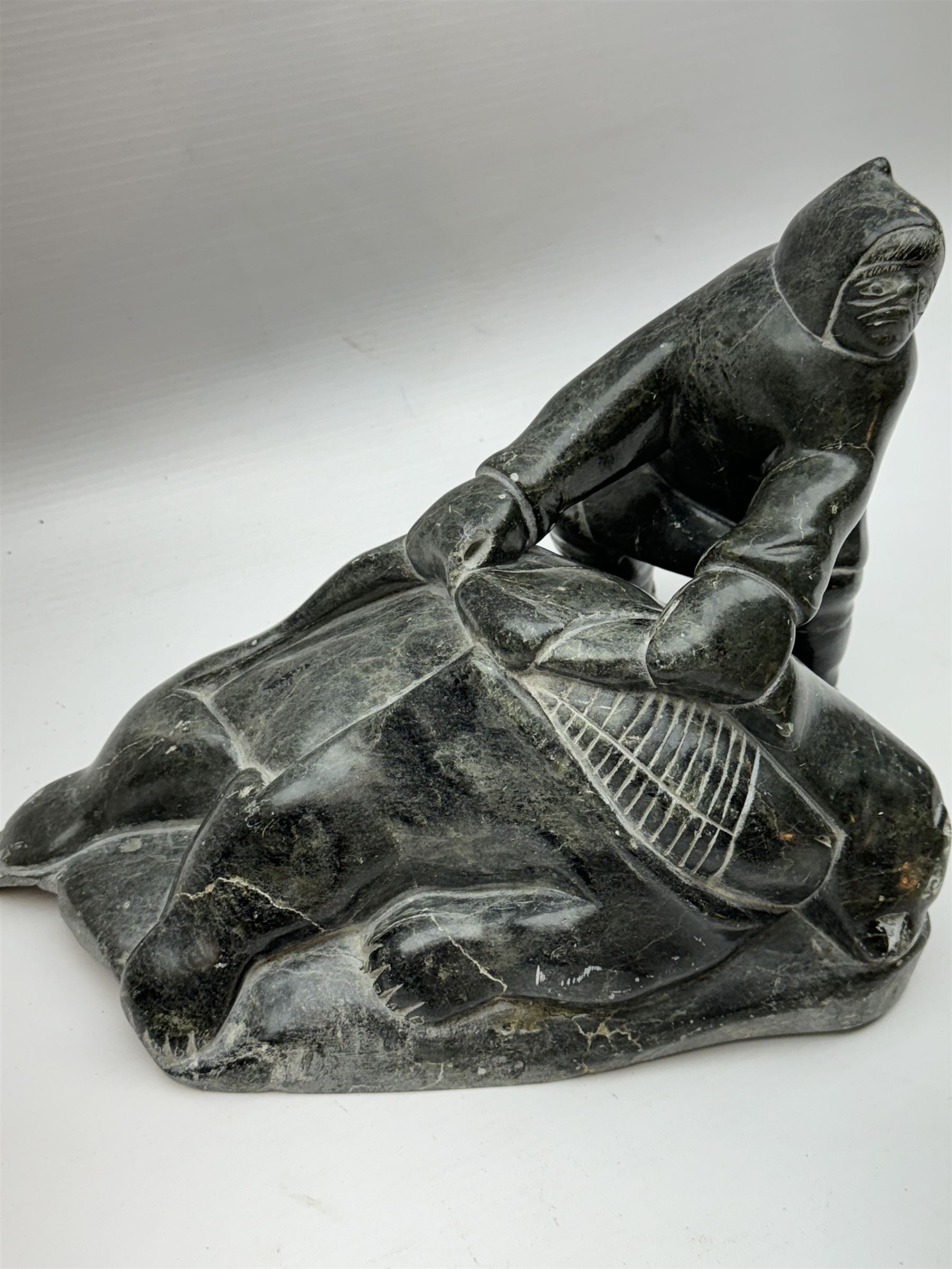 Inuit soapstone carving, of a hunter and a polar bear, circa 1960, H19cm 