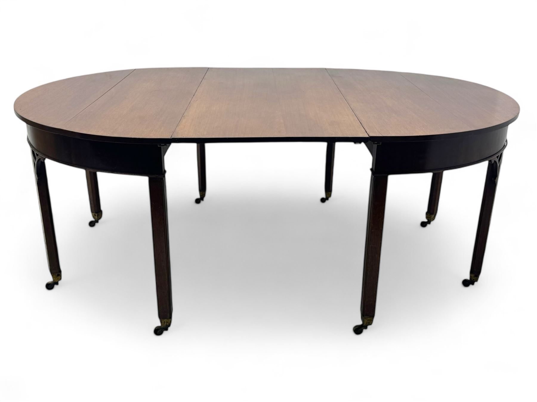 Early 19th century mahogany demi-lune extending dining table, two D-ends with central leaf insert, raised on eight square supports with arched spandrels terminating in brass castors