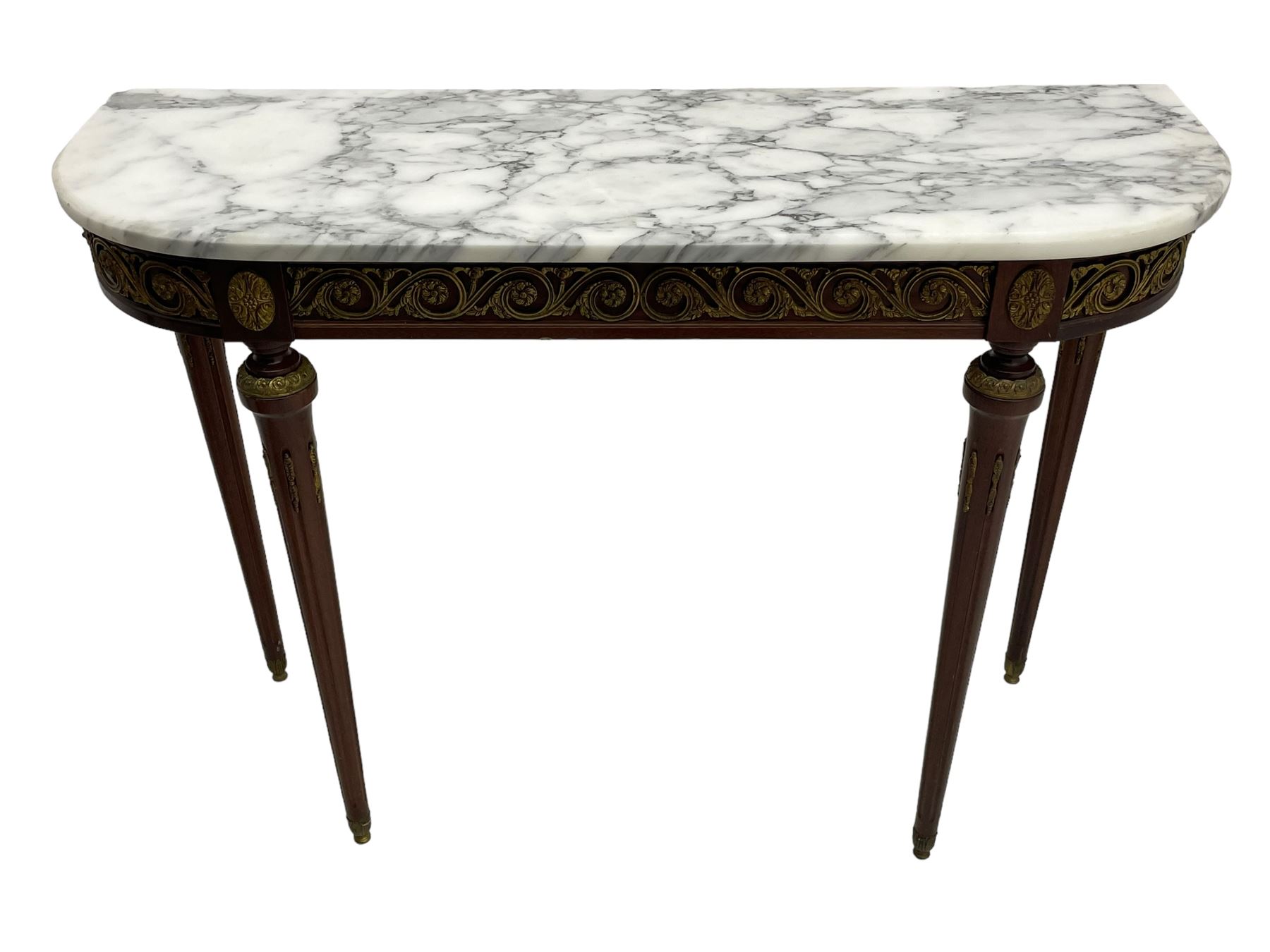 Pair of late 20th century French design mahogany console tables, D-end form with white and grey veined marble tops, the frieze rails decorated with scrolled leaf and flower head cast brass mounts, on turned and fluted supports with cast brass mounts and feet 