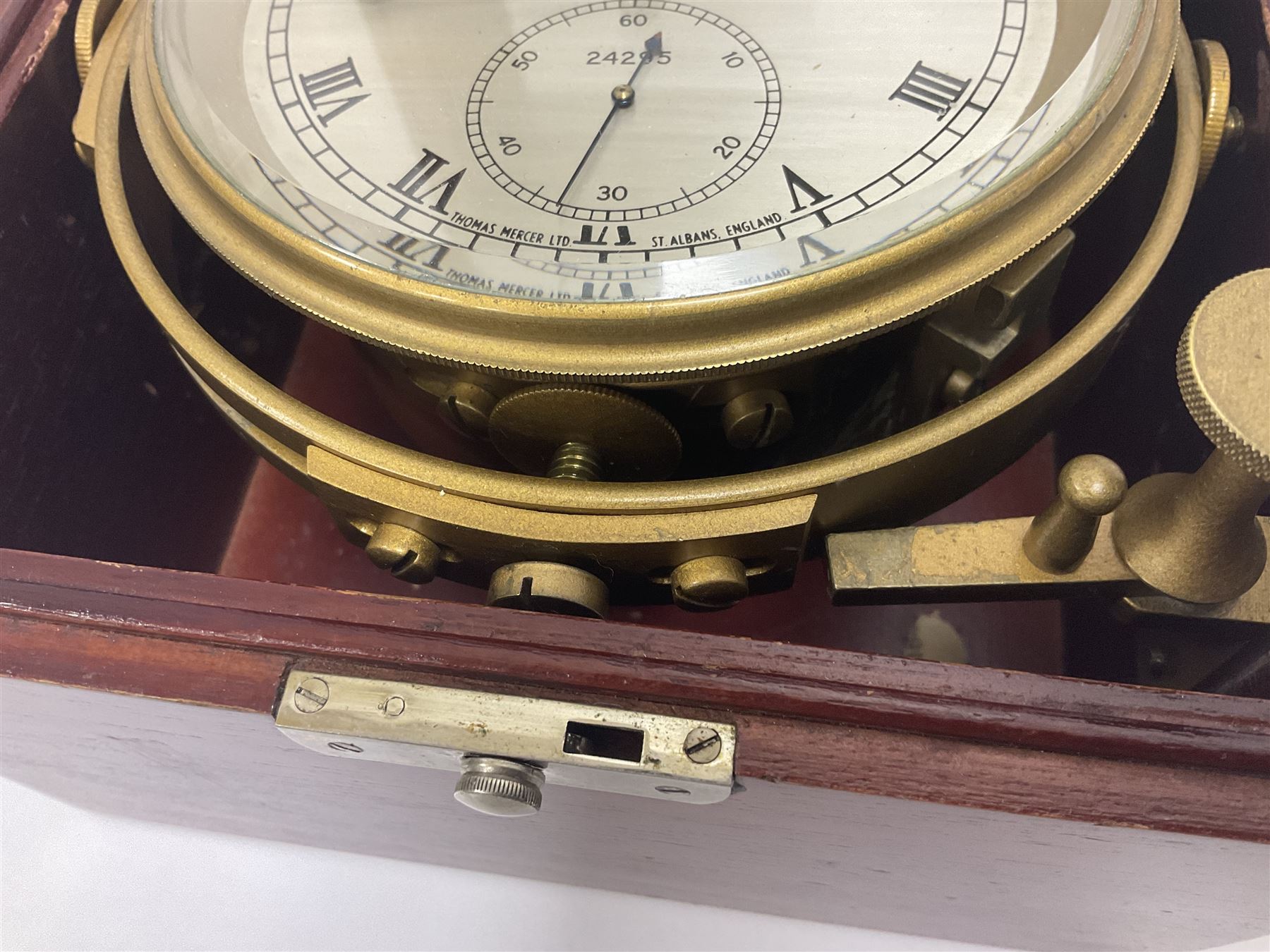 Two-day marine chronometer, with silvered dial inscribed Thomas Mercer Ltd, St Albans, contained within a brass gimbal-mounted bowl and glazed mahogany case, with applied brass plaque reading 'supplied by Kelvin Hughes no. 24295', brass winding key and two service notes to interior of case, dial D12cm, wooden case H17.5cm 