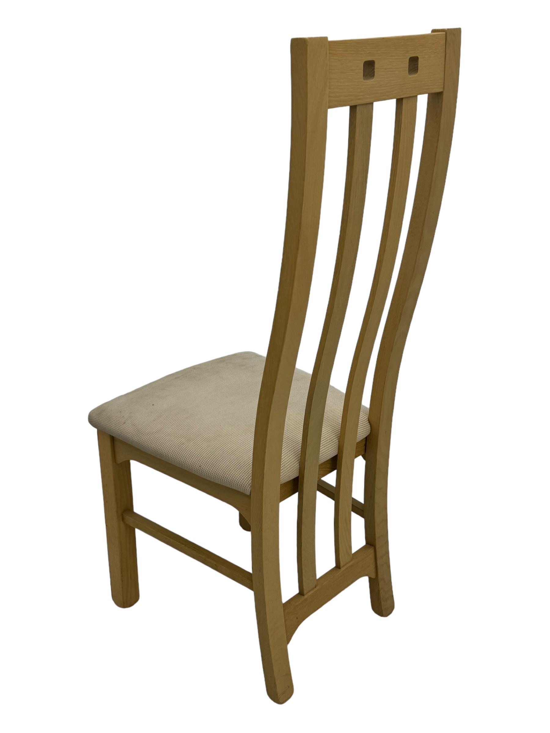 Contemporary set of four oak dining chairs, tall slatted curved backs with square cutouts to the top, upholstered seats in light fabric, on square front supports