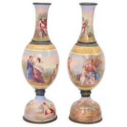 Pair of late 19th century Austrian silver and enamel vases by Hermann Böhm, of baluster form, overall decorated the top depicting musical scenes and oratory with reclining figures in togas, the ovoid bodies painted with Dithyramb scenes portraying Dionysiac worshippers playing the cymbals, pan pipes and lyre, with a dancing Maenad bearing a Thyrsus beside, and surrounding figures consuming wine, the domed pedestal feet depicting the Greek gods observing from the clouds with Putti, and recovering a lost statue from ploughed fields, within foliate silver mounts, marked A for Vienna and maker's mark HB, H21cm (2)