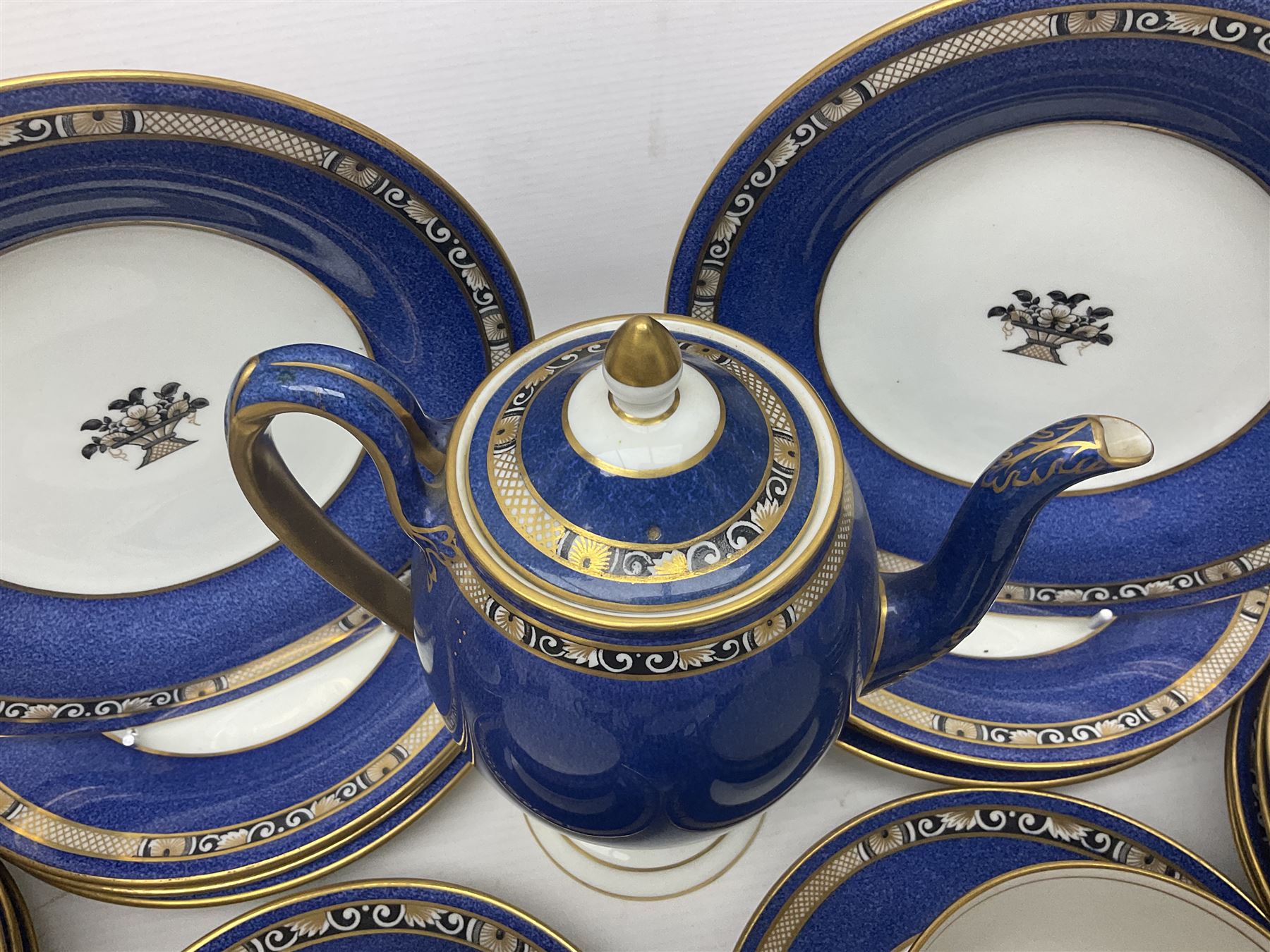 Wedgwood part tea and coffee service, comprising coffee pot, six coffee cans with five saucers, seven teacups with ten saucers and seven side plates, each decorated with floral bouquet to centre, in a gilt and speckled blue border, pattern x9933, with printed mark beneath