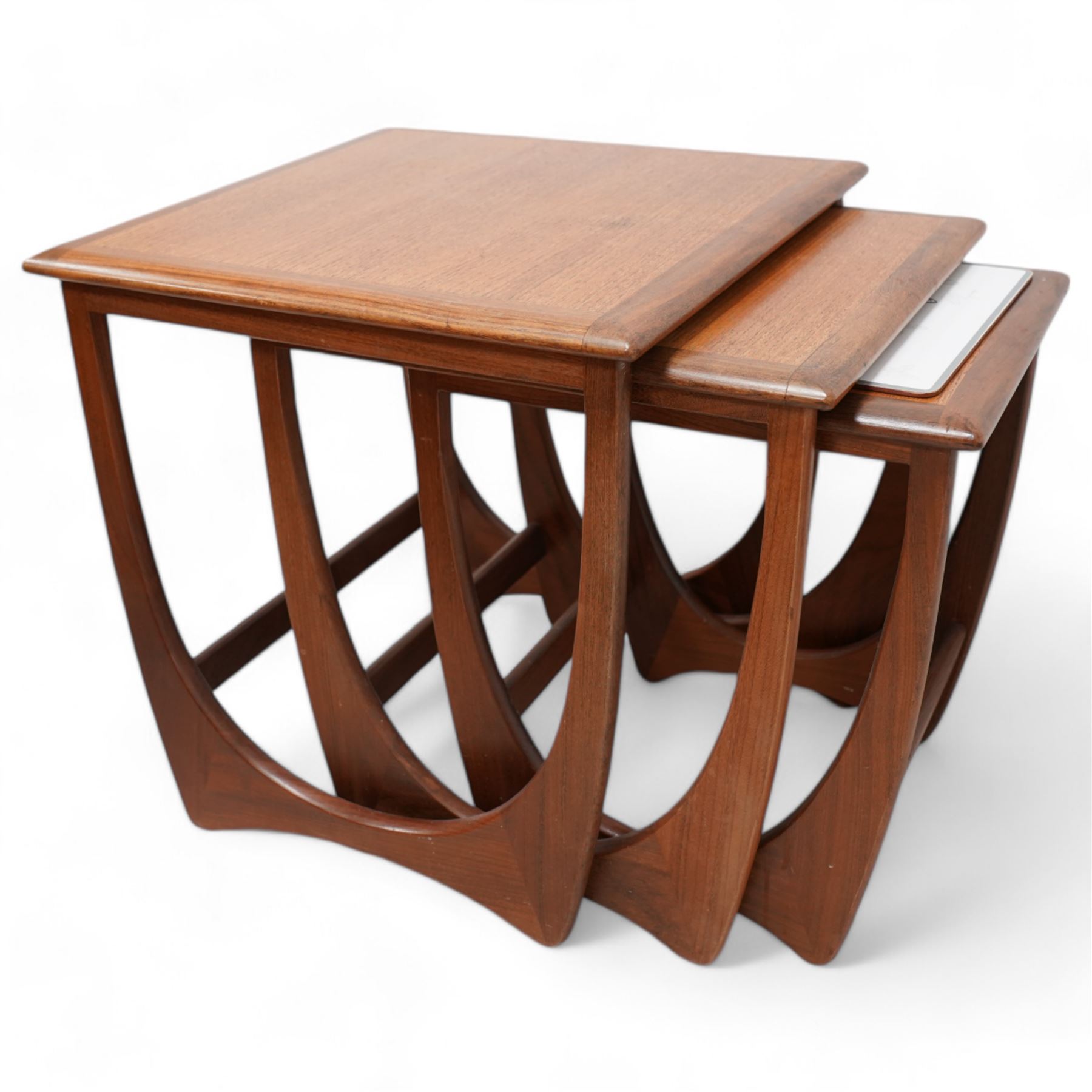 G-Plan - mid-20th century 'Astro' teak nest of three tables, on curved end supports joined by stretchers