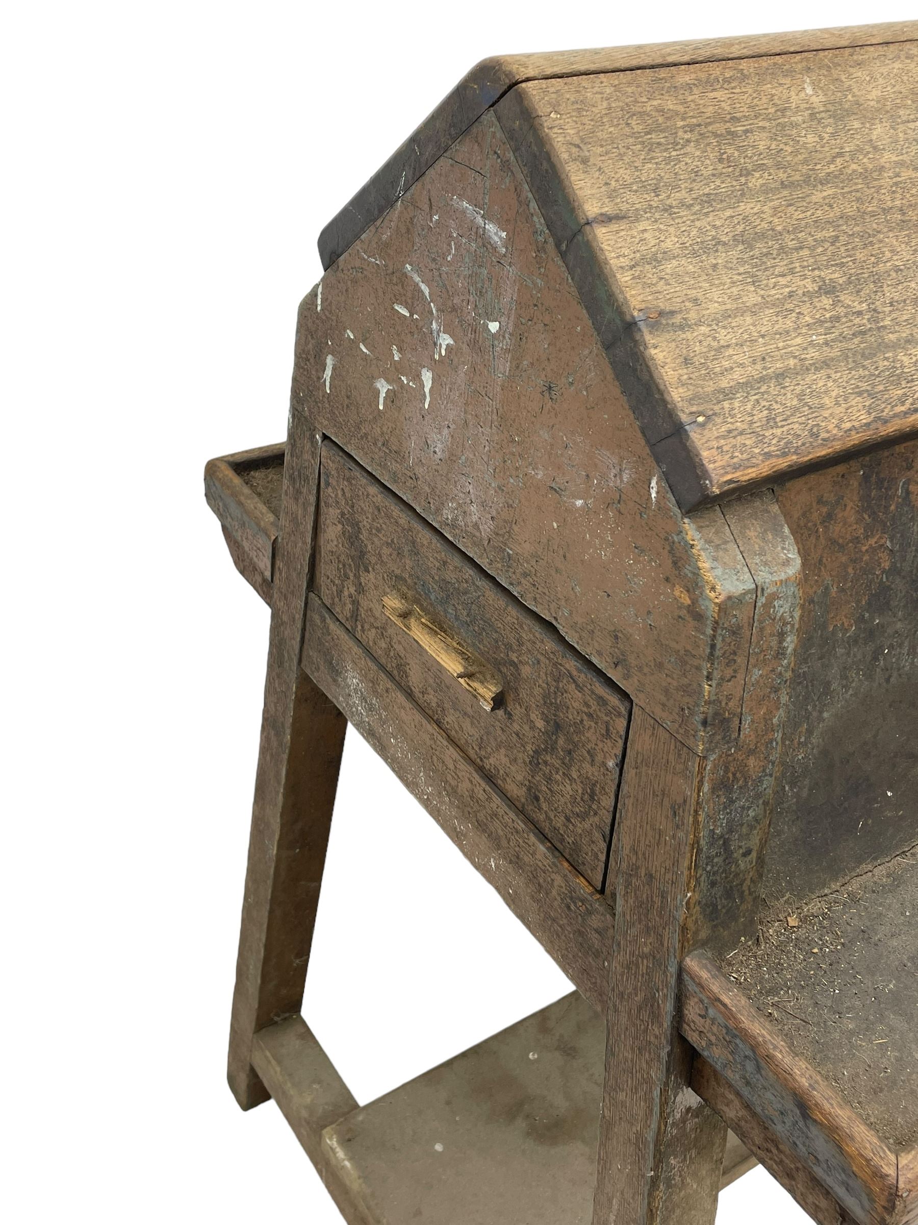 19th century teak saddle horse, A-frame on trestle base, fitted with shelves at either side and end drawers, on square supports united by undertier 