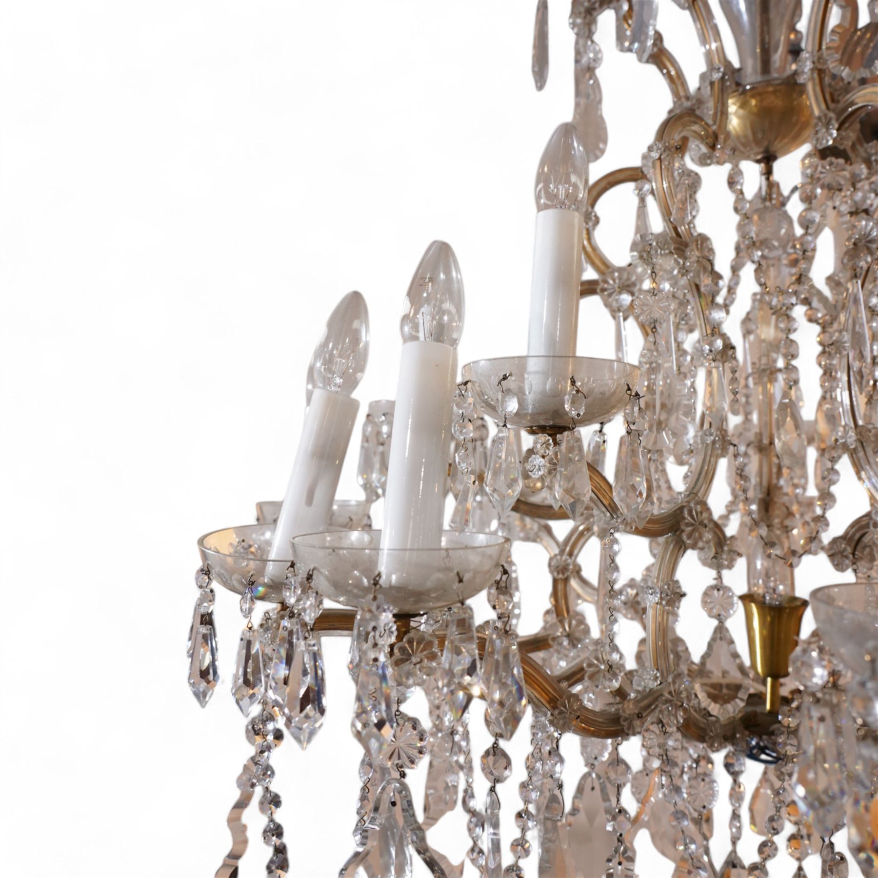 Large mid-to-late 20th century two-tier glass chandelier, shaped body dish over glass column, serpentine metal frame supporting fifteen branches, the frame clad with glass panels and decorated with drop pendants, each branch with glass bobeche decorated with drop prisms 