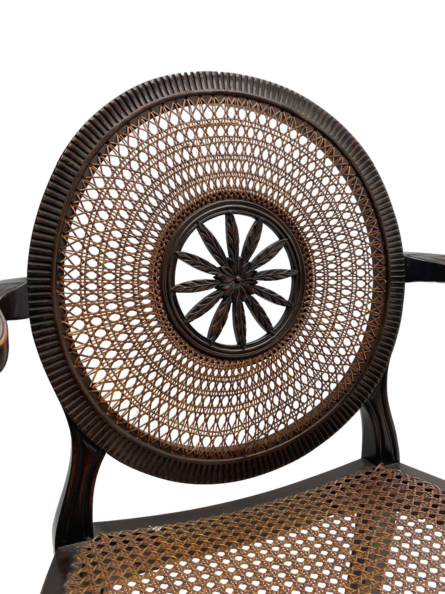 Mid-to late 20th century walnut Hepplewhite design elbow chair, circular cane back with pierced and carved central rosette, fluted frame with scrolling arms, cane seat raised on fluted rail and square tapering supports with spade feet